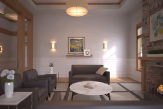 A modern lounge area with sofas, a round marble coffee table, and wall art.