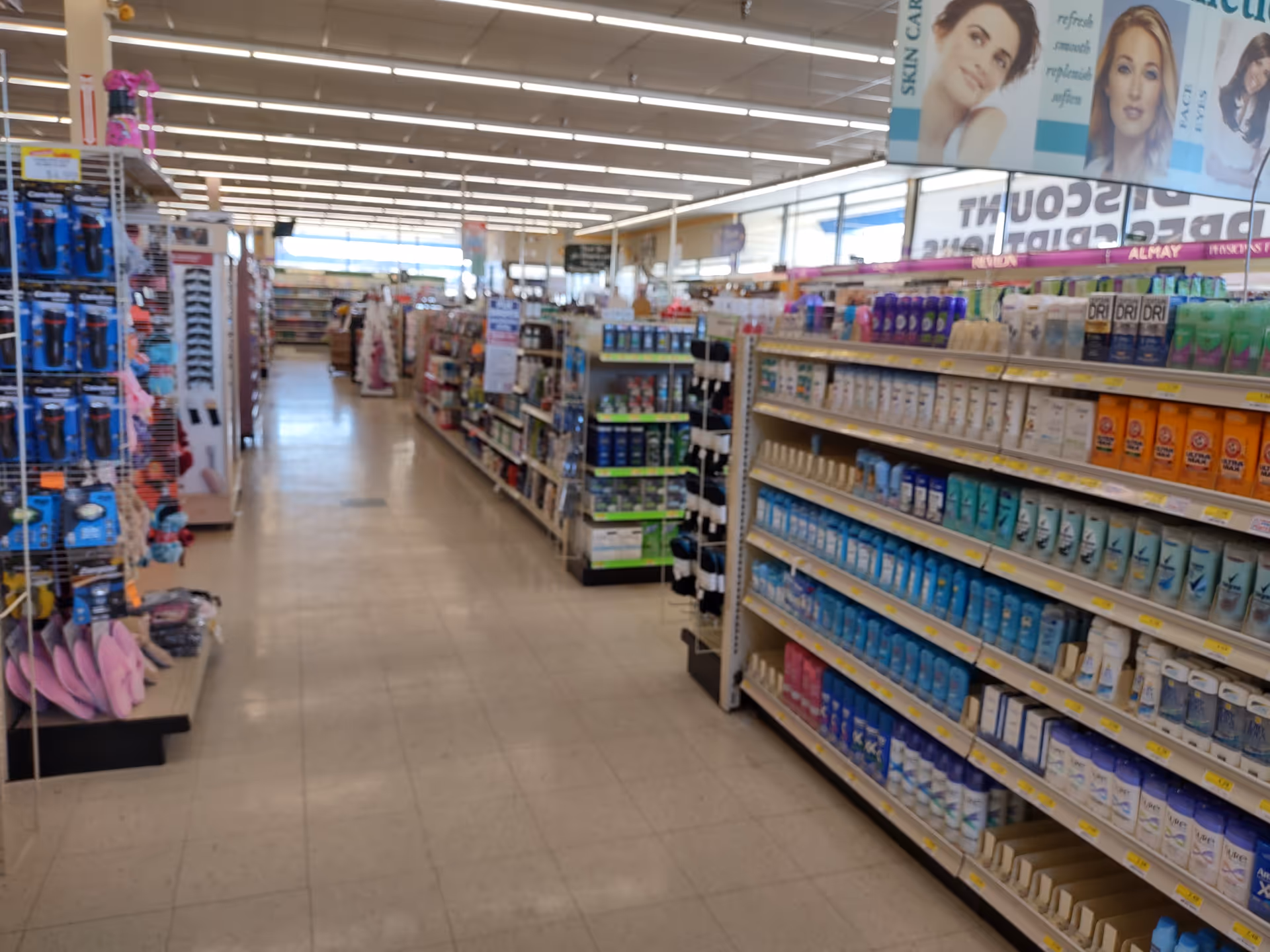 Bright interior of a Discount Drug Mart aisle filled with health and personal care products.