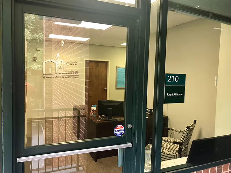 Interior office lobby of Right at Home with reception desk and doorway.