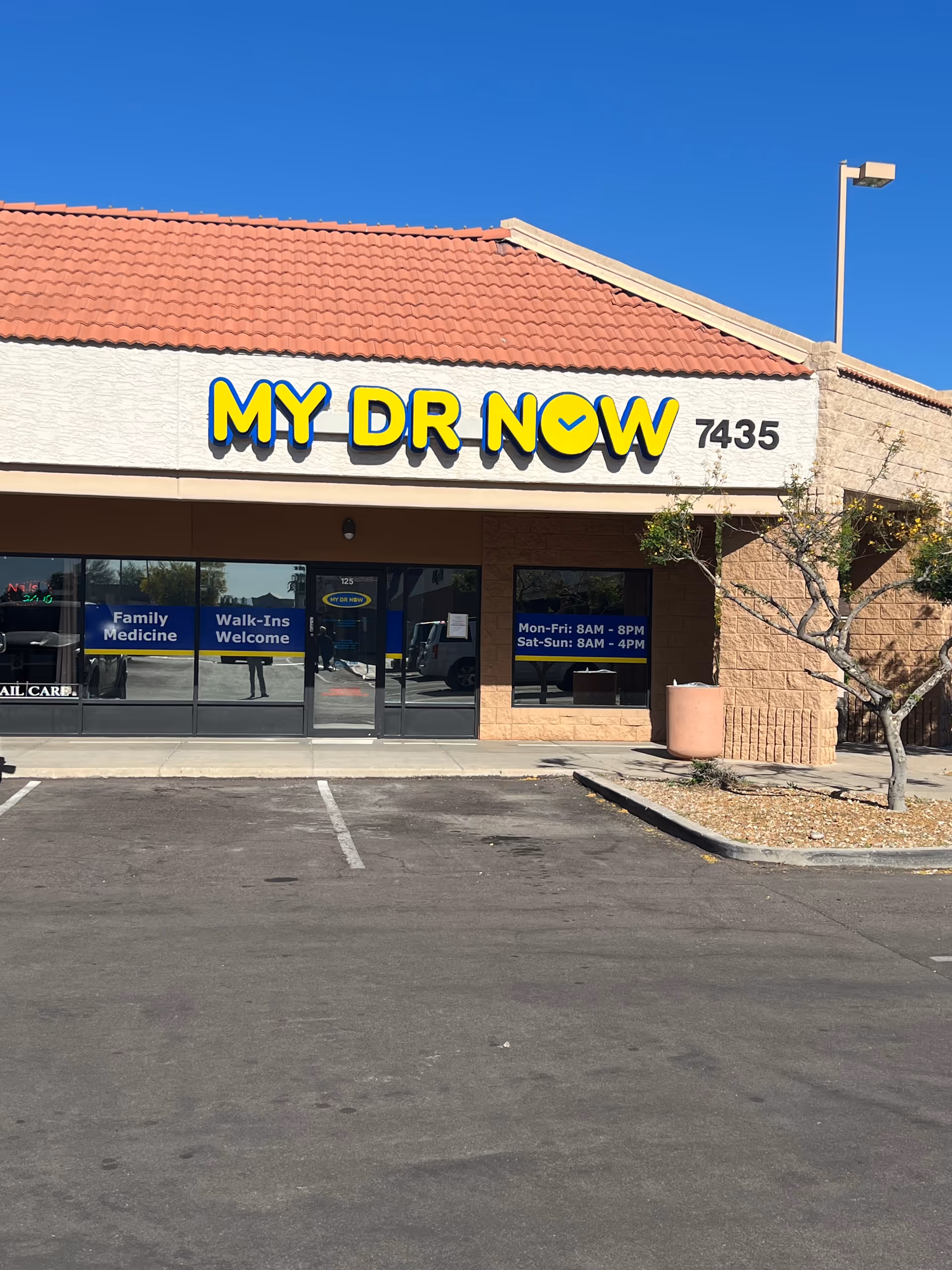 Front view of MY DR NOW clinic storefront with sign, glass doors, and parking lot.