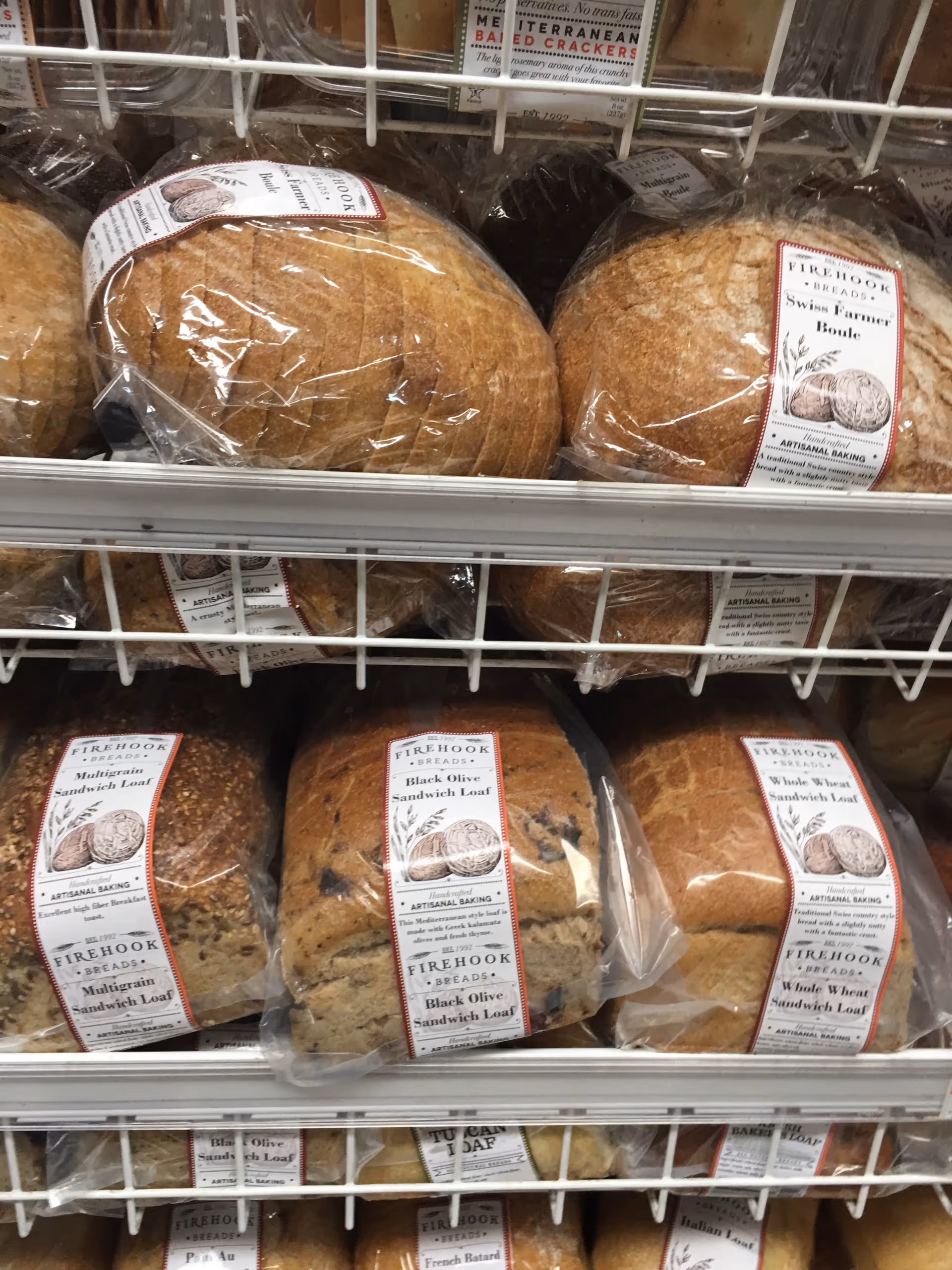 Rows of packaged bread loaves on wire shelves in a pantry.