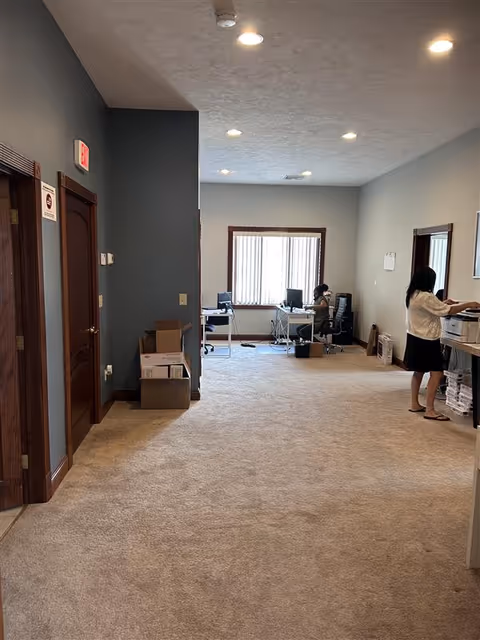 Interior hallway of a senior care facility with desks and staff at work.