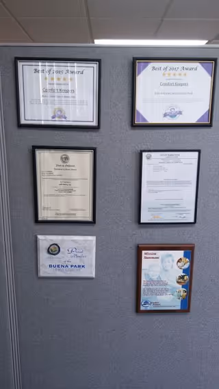 Wall covered with six framed certificates and awards for Comfort Keepers Home Care.