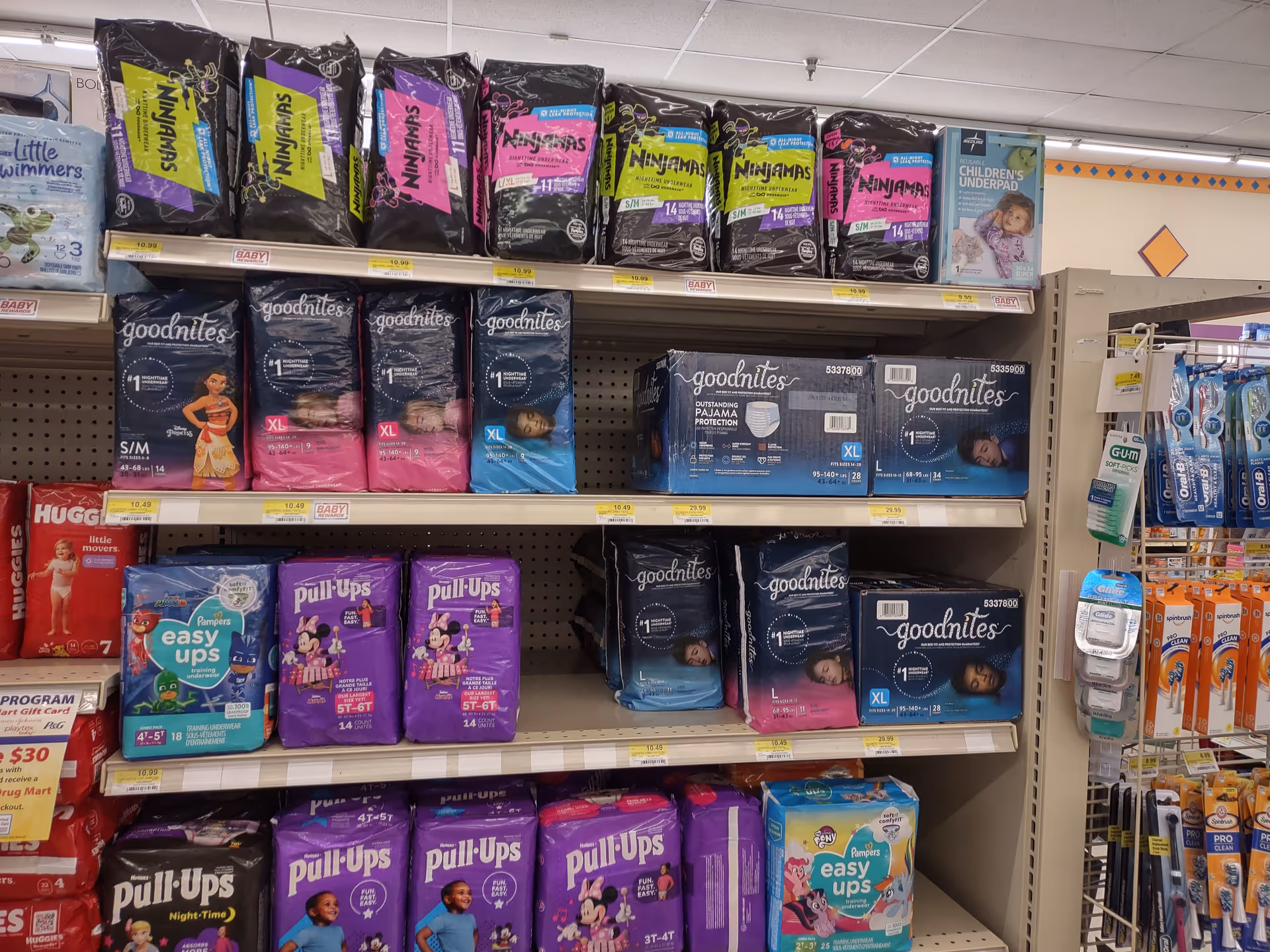 Aisle of diaper packages on store shelves at Discount Drug Mart.