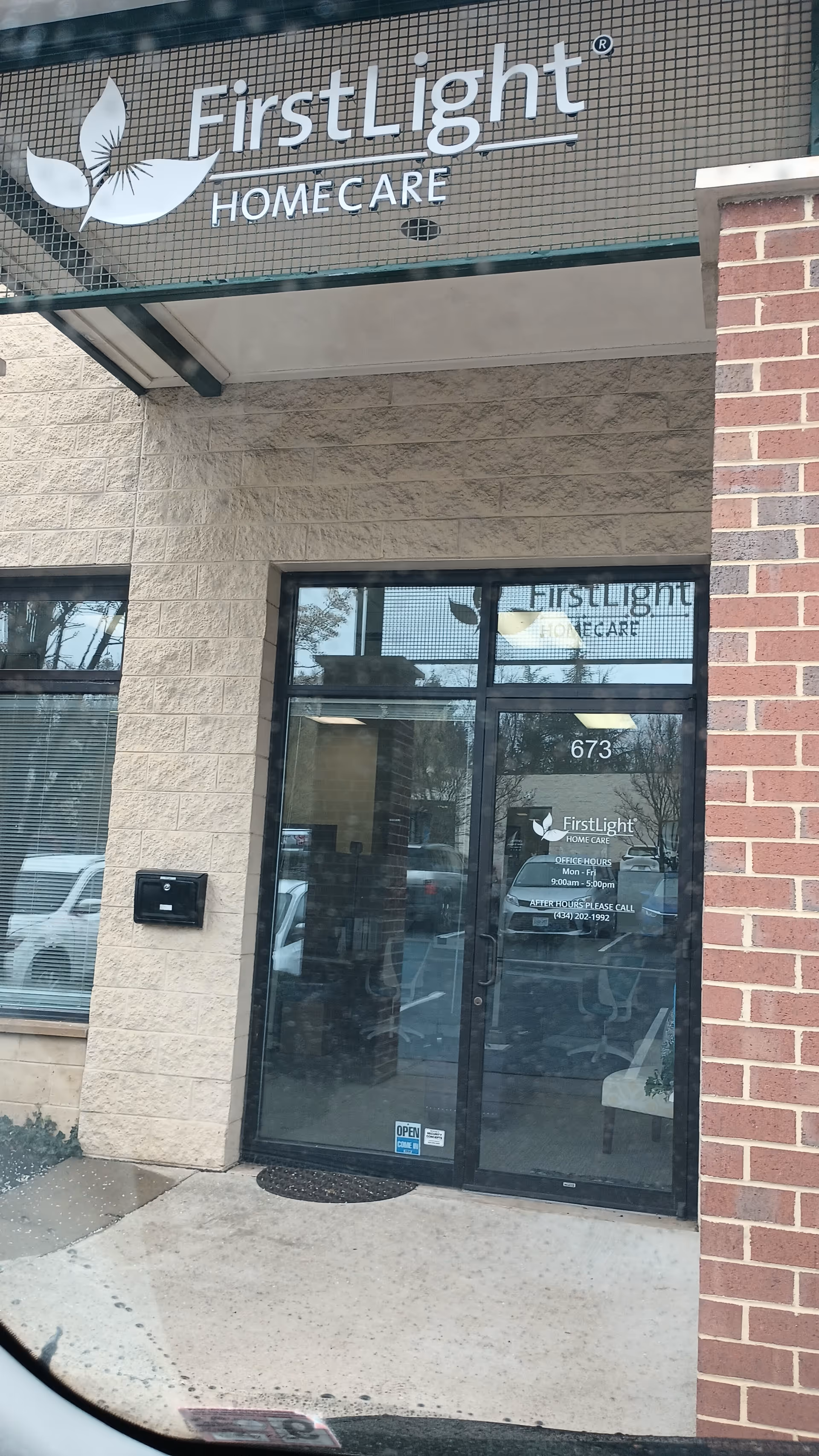 Exterior view of FirstLight Home Care entrance with glass door and brick facade.