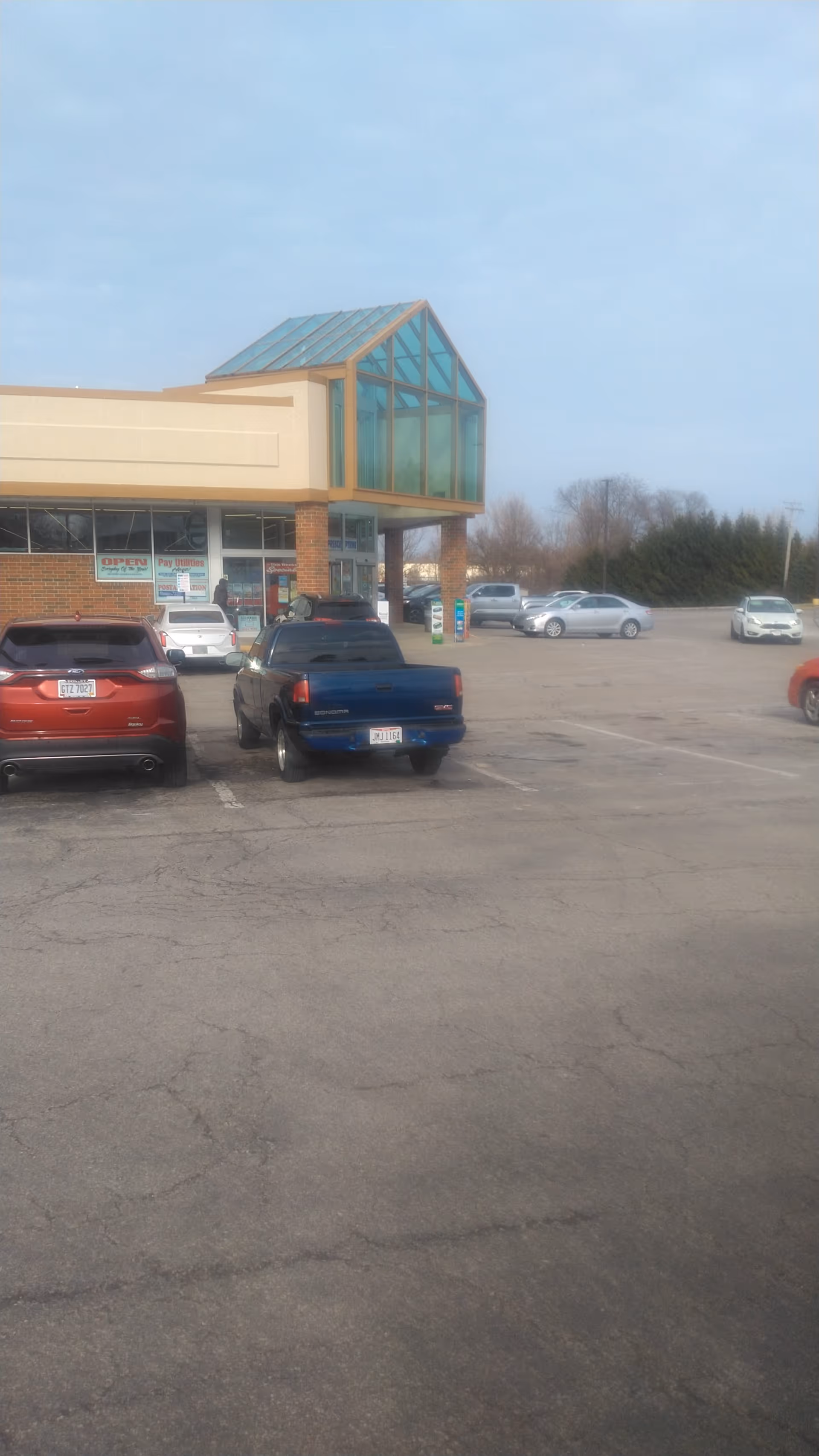 Shopping center storefront Discount Drug Mart with glass entrance and parked cars