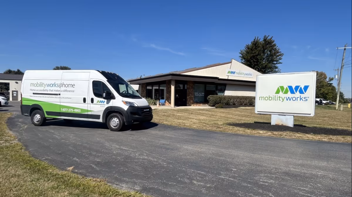 A MobilityWorks van is parked in front of a single-story facility with a large sign.
