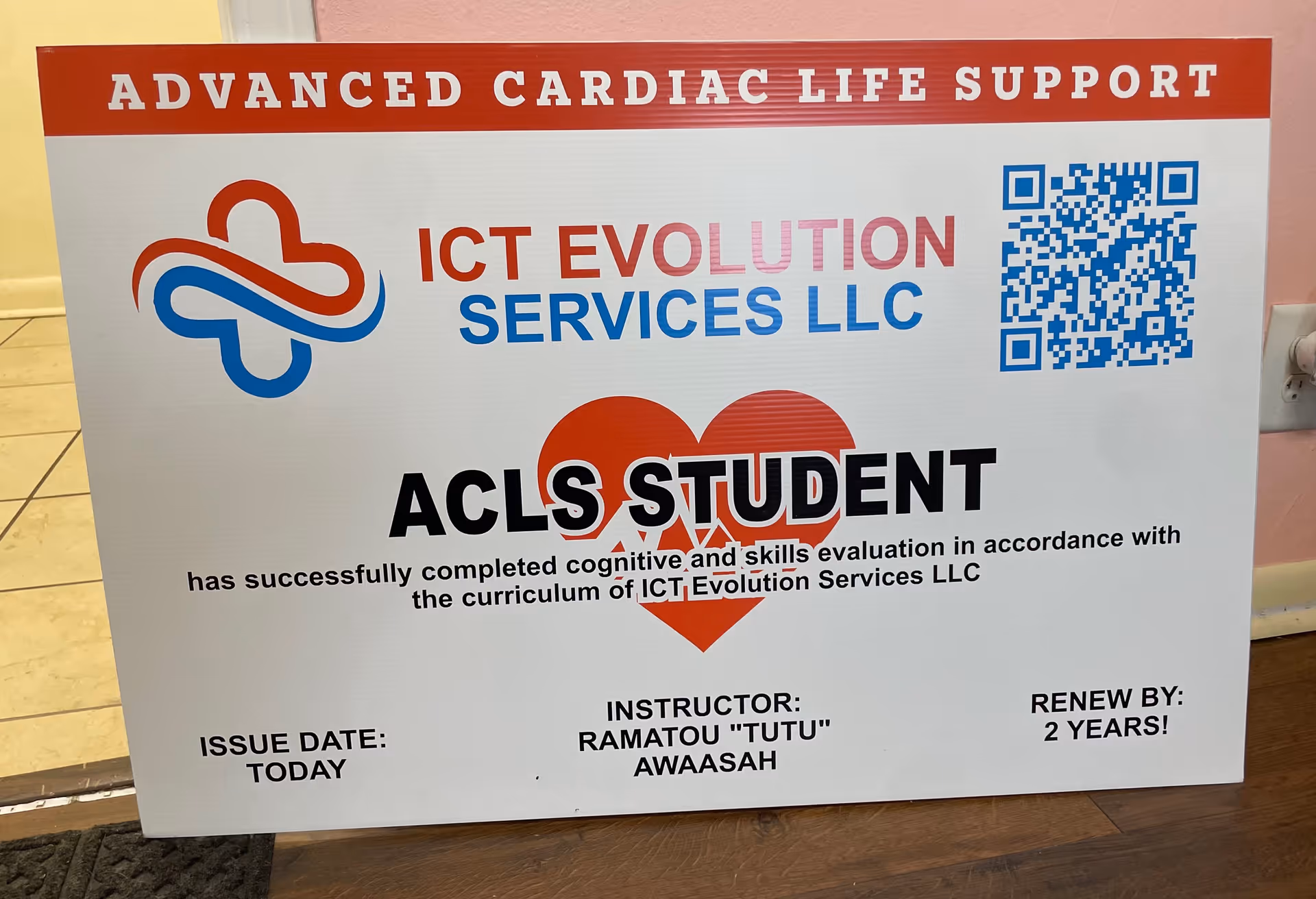 A large ACLS signboard for ICT Evolution Services in an interior hallway.