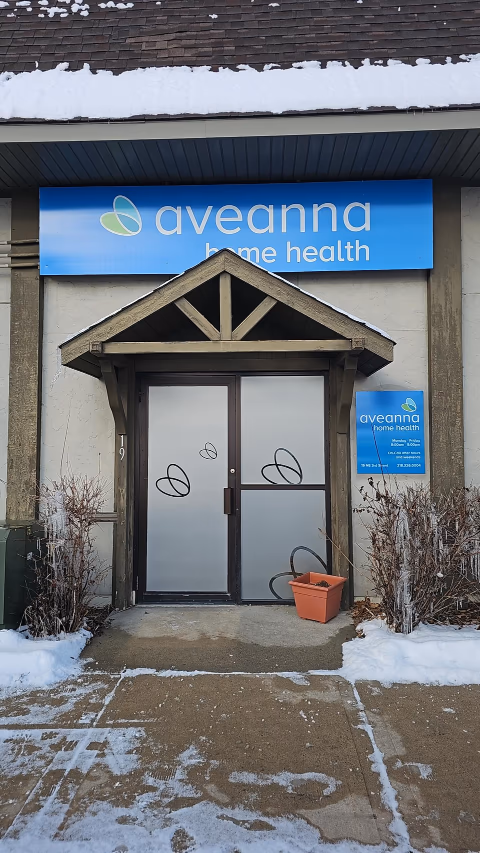 Front entrance of Aveanna Home Health with blue sign and frosted doors.