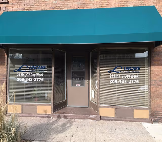 Storefront of LINCARE facility with green awning and central door flanked by windows