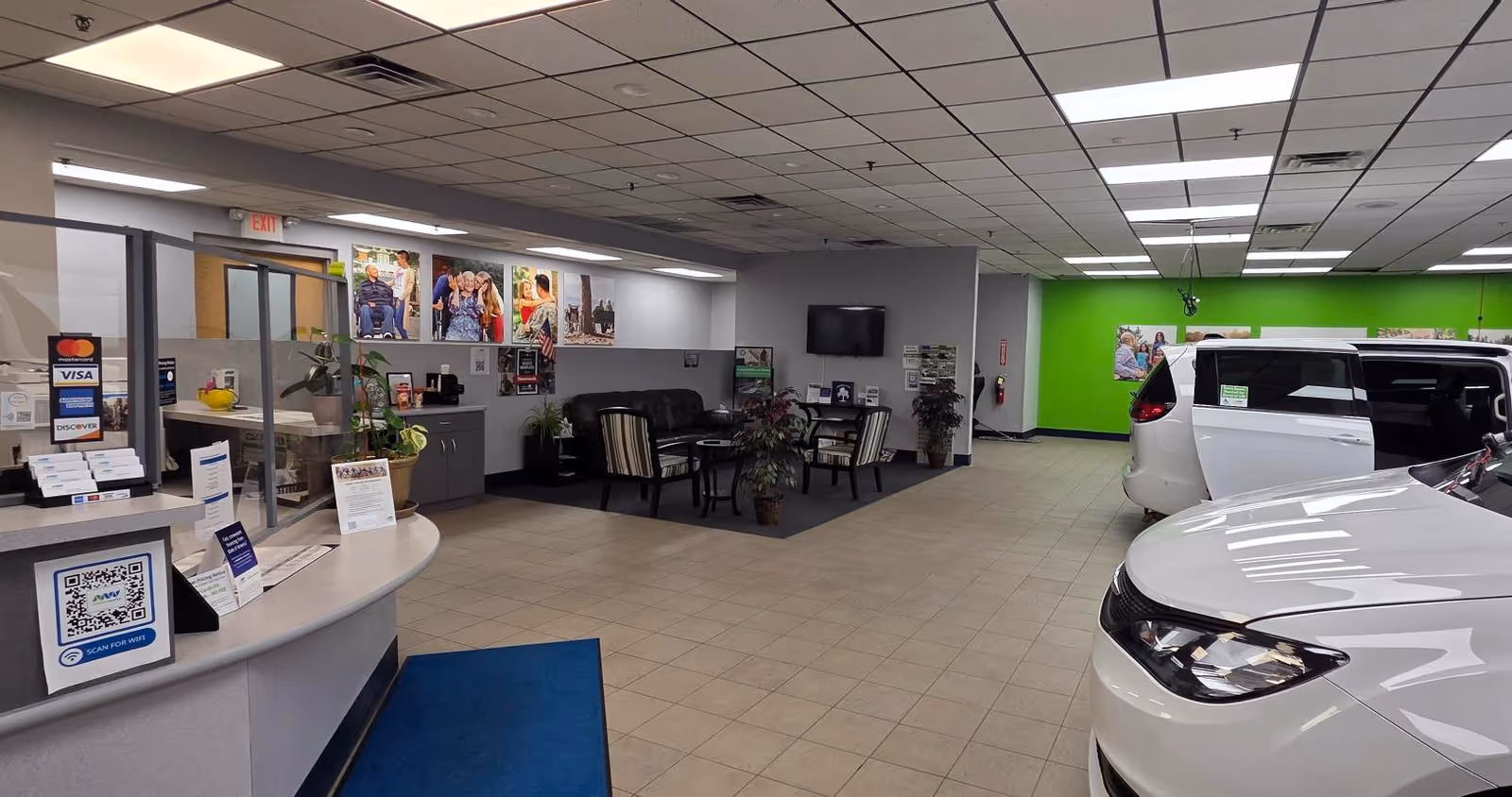 Indoor MobilityWorks showroom with cars, a reception desk, and seating area.