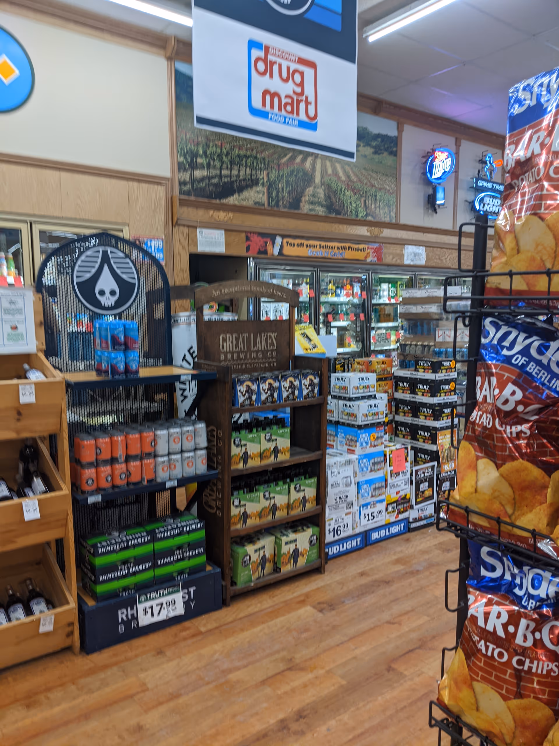 Inside Discount Drug Mart, aisles with beverages, snacks, and a prominent beer display.
