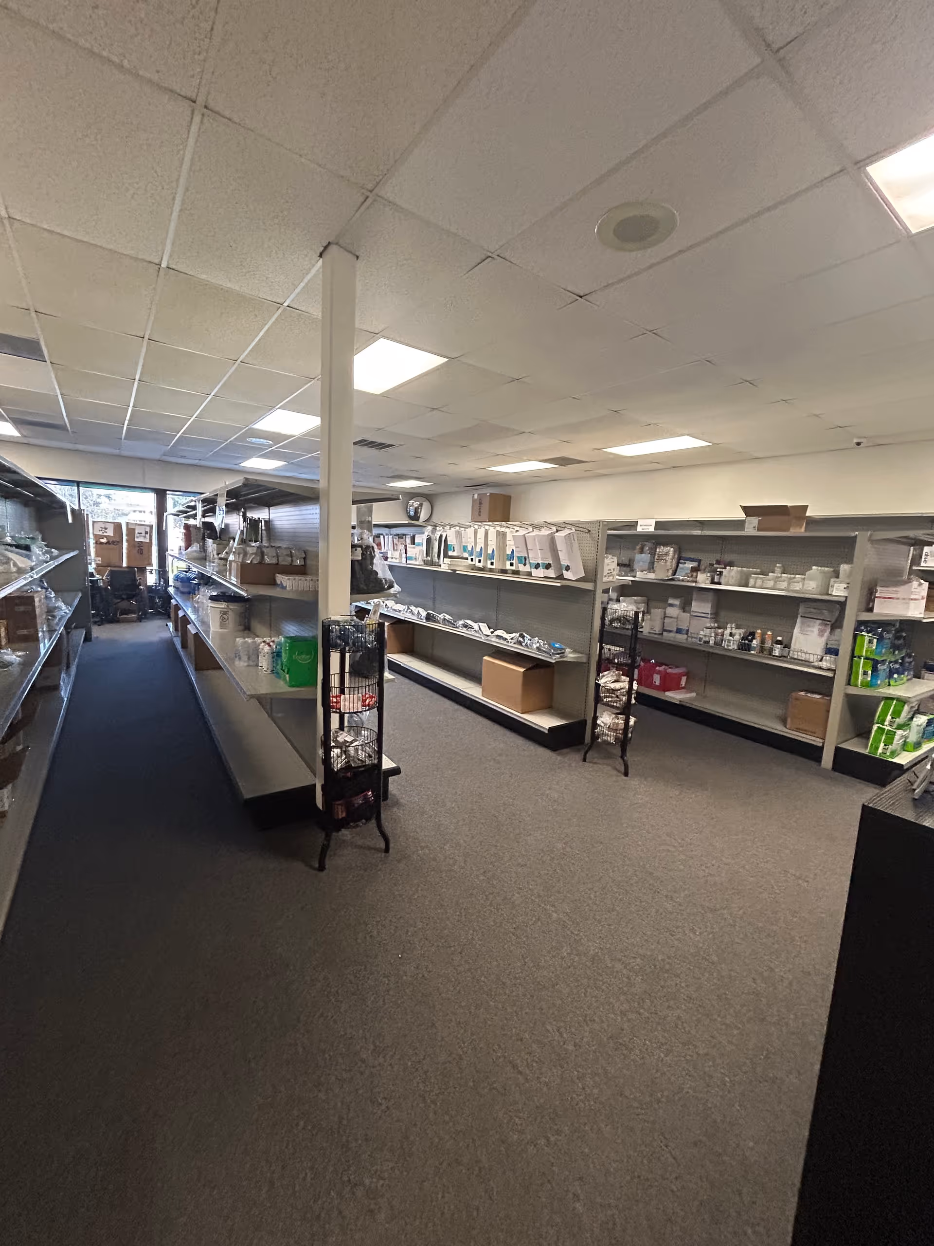Long interior corridor with shelves of medical supplies along both walls.