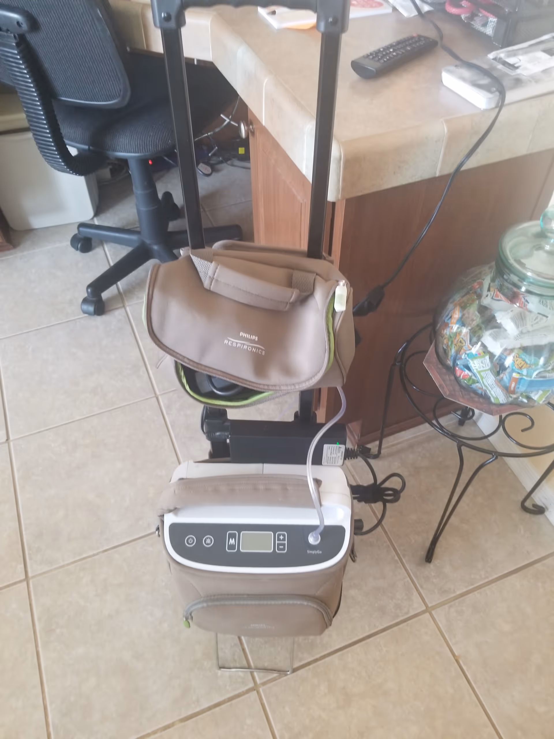 Interior scene showing a wheeled medical lift device beside a Philips Respironics CPAP bag.