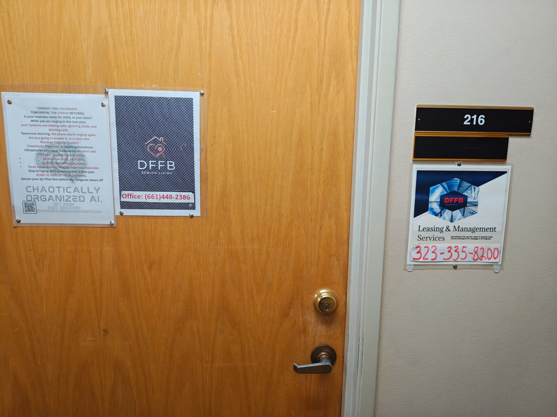 Wooden interior door with posted notices in a hallway showing room 216