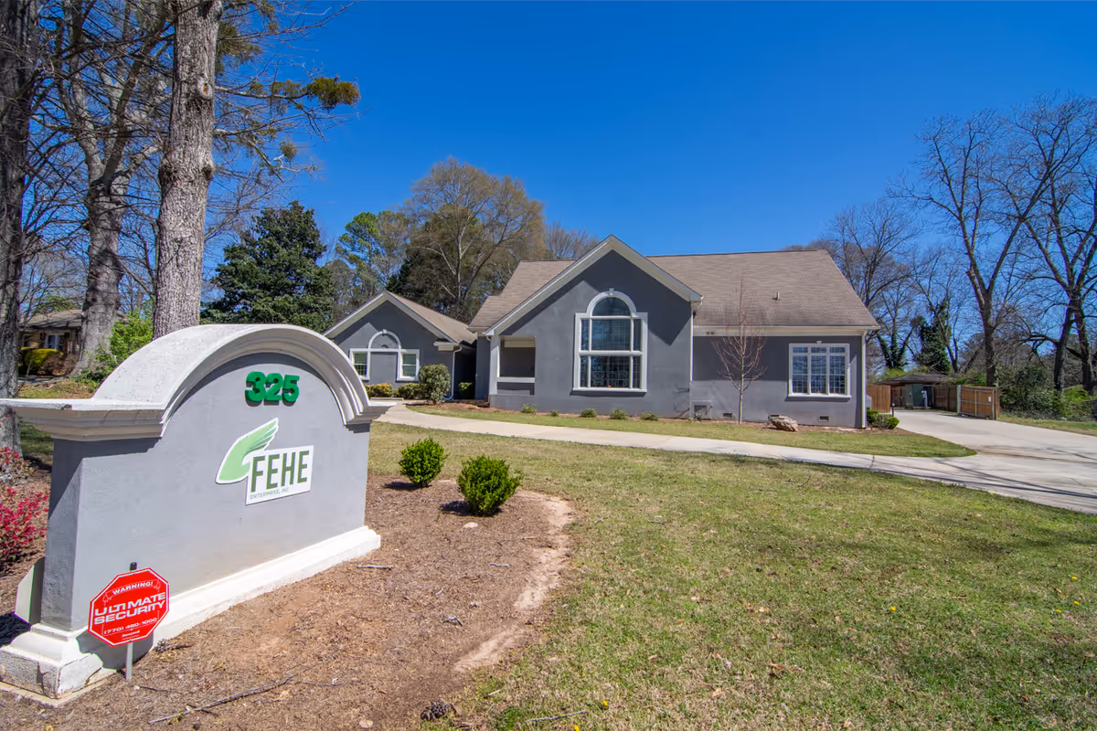 A single-story gray Fehe Private Healthcare Services facility with a curved entrance and sign.