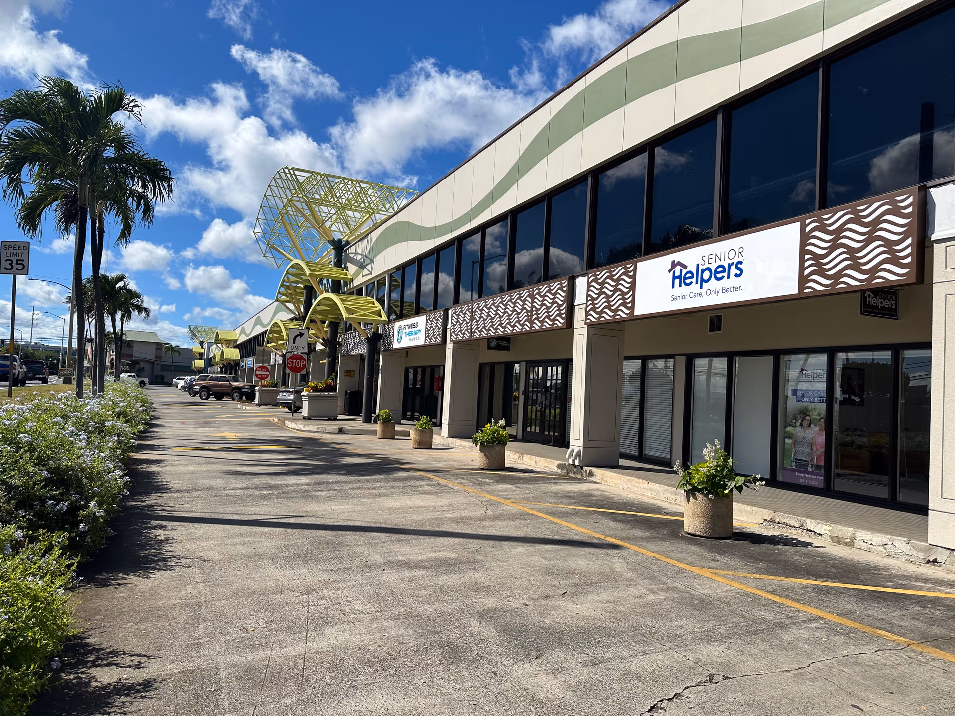 Exterior view of a Senior Helpers storefront with palm trees and a parking lot.