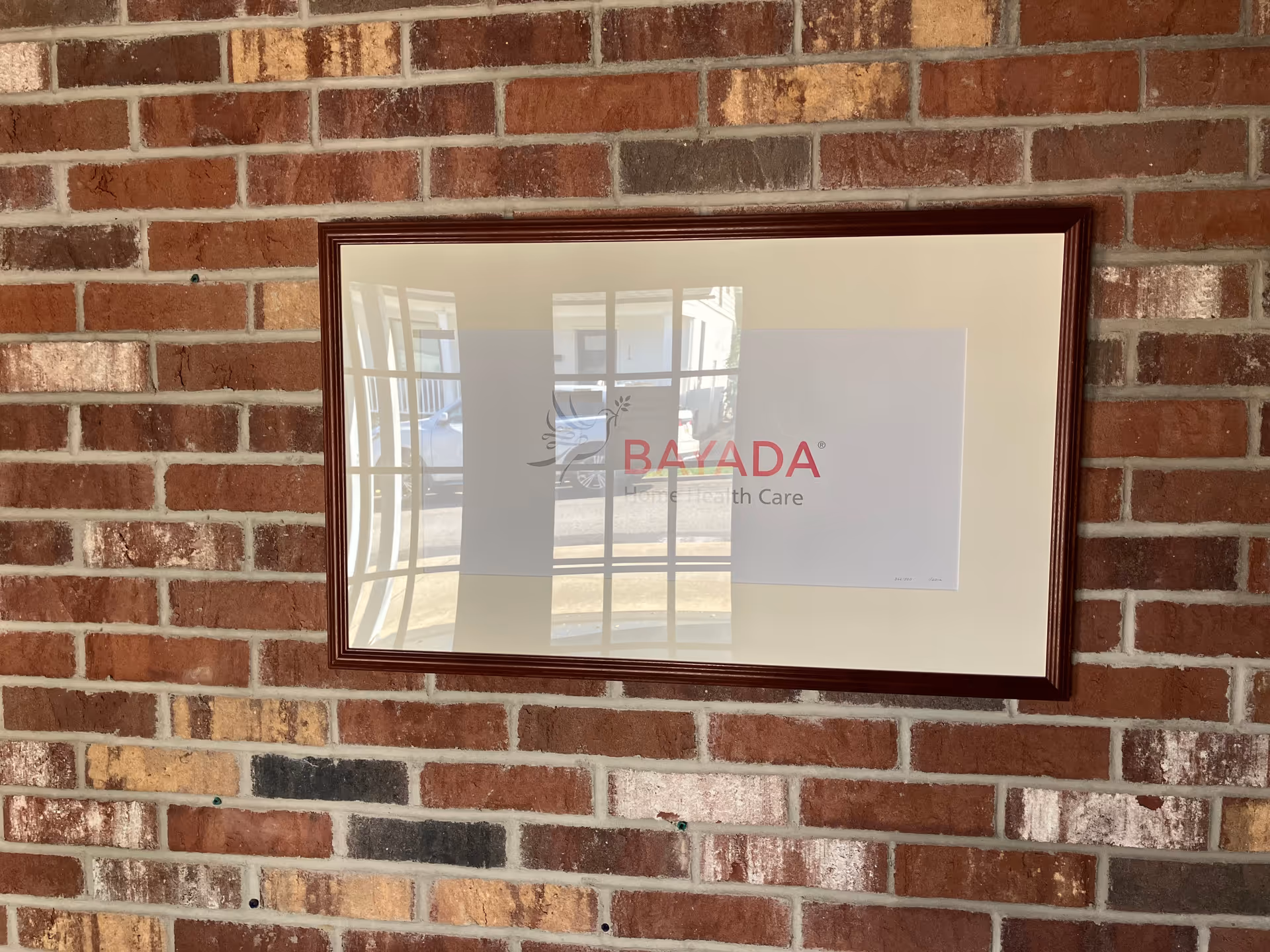 Framed BAYADA Pediatrics sign on a brick interior wall.