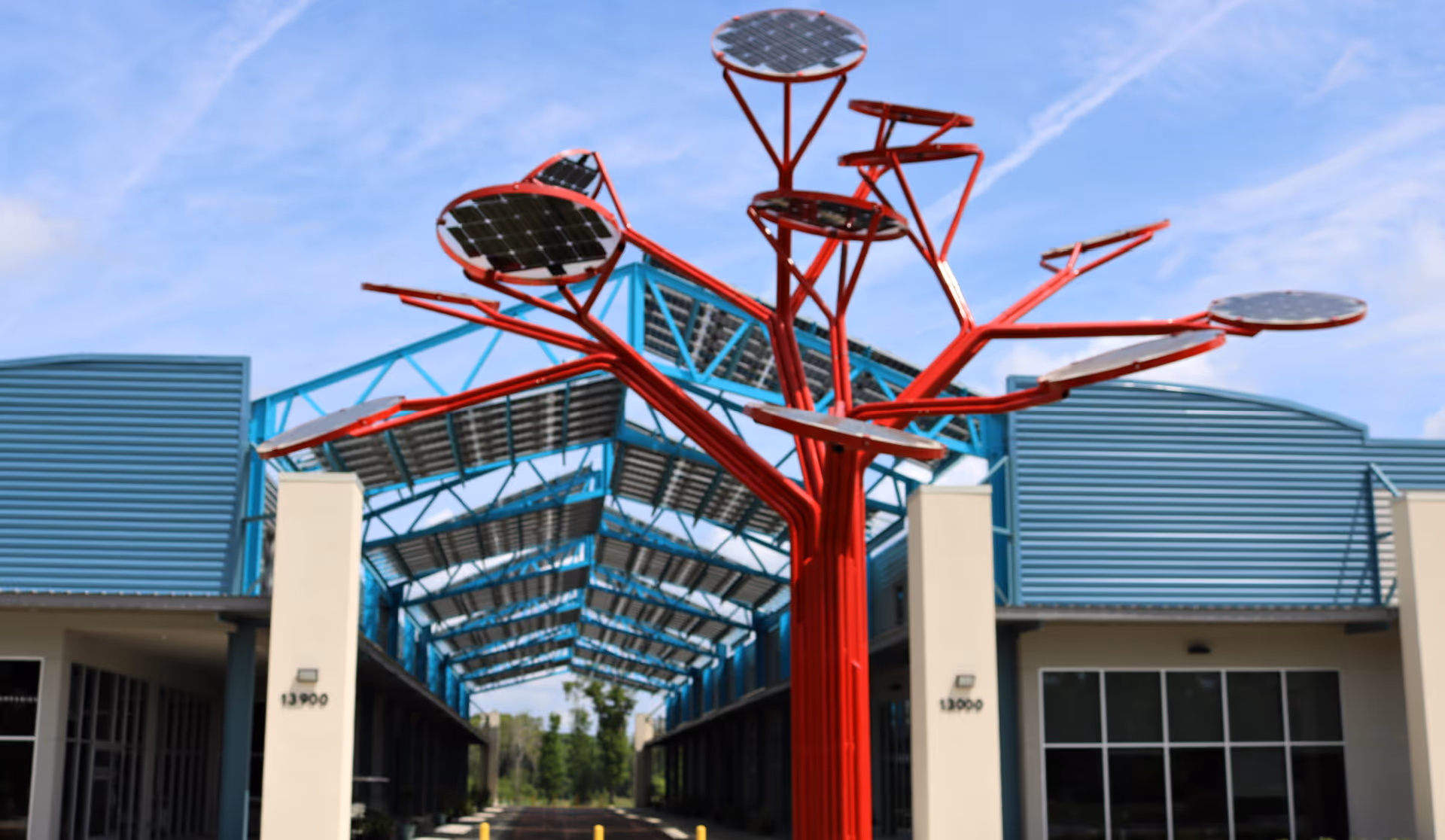 Exterior view of a hospice facility with a bright red tree-like sculpture near the entrance