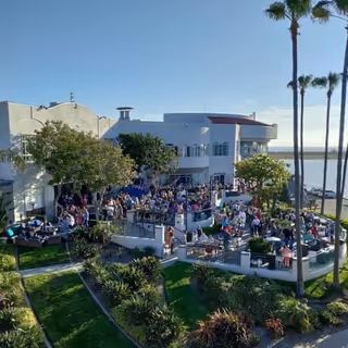 Outdoor dining terrace at a senior facility crowded with residents and staff.