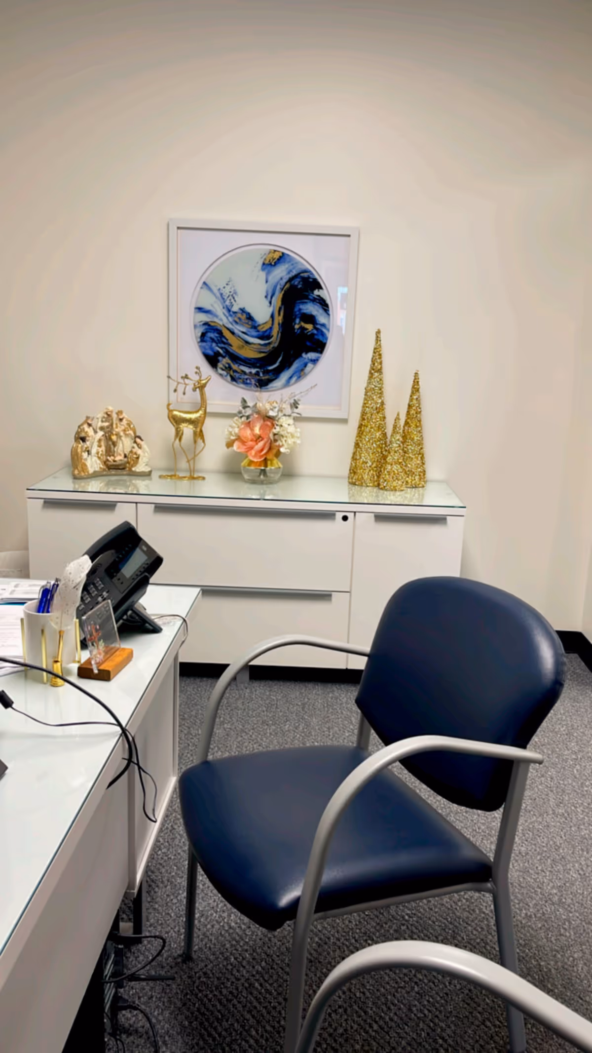 A reception desk with a blue chair in a clean office area and decor.