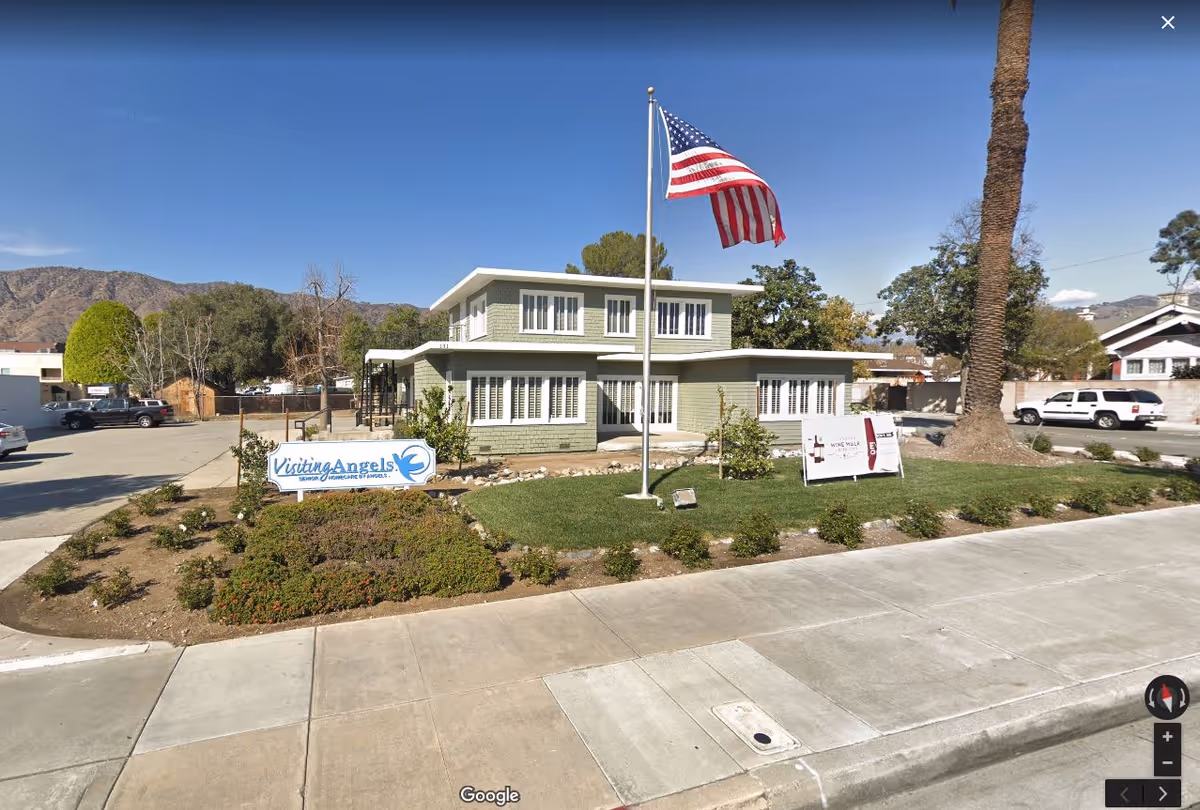 Exterior view of Visiting Angels Senior Home Care building with flag and landscaping.