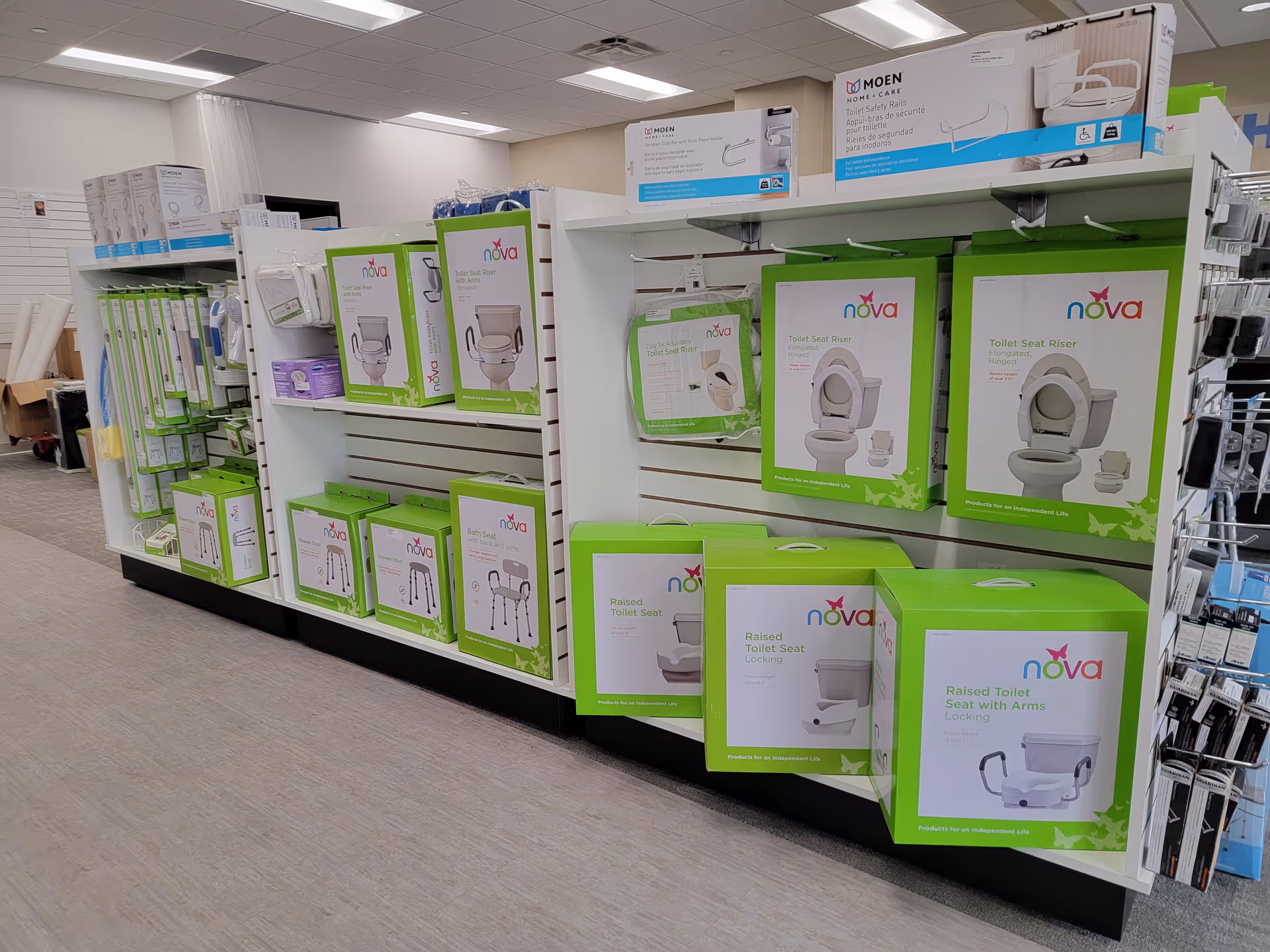 Retail display of Nova toilet seats and bathroom aids on store shelves.