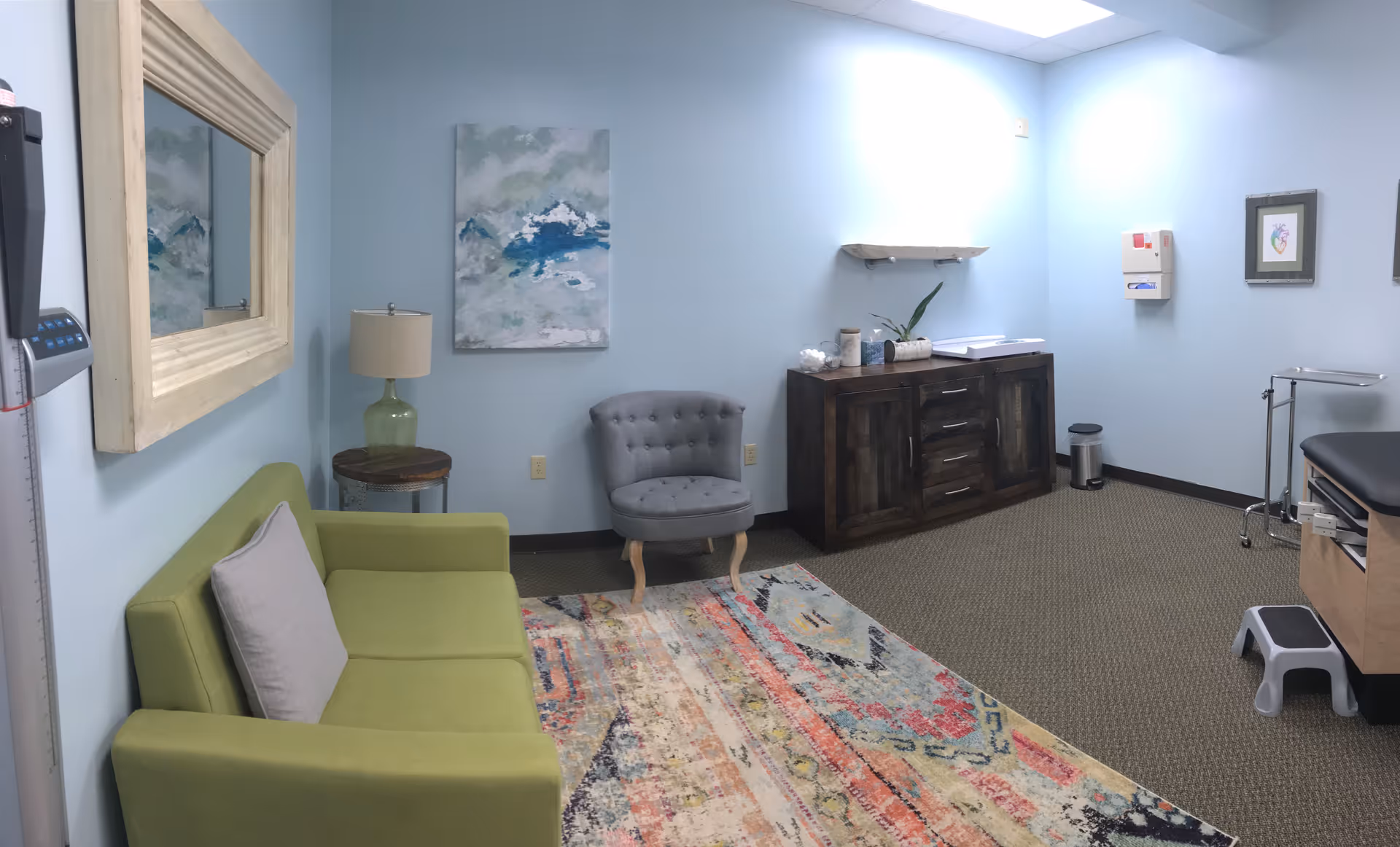 Blue-walled senior living waiting lounge with lime-green sofa and gray tufted chair.