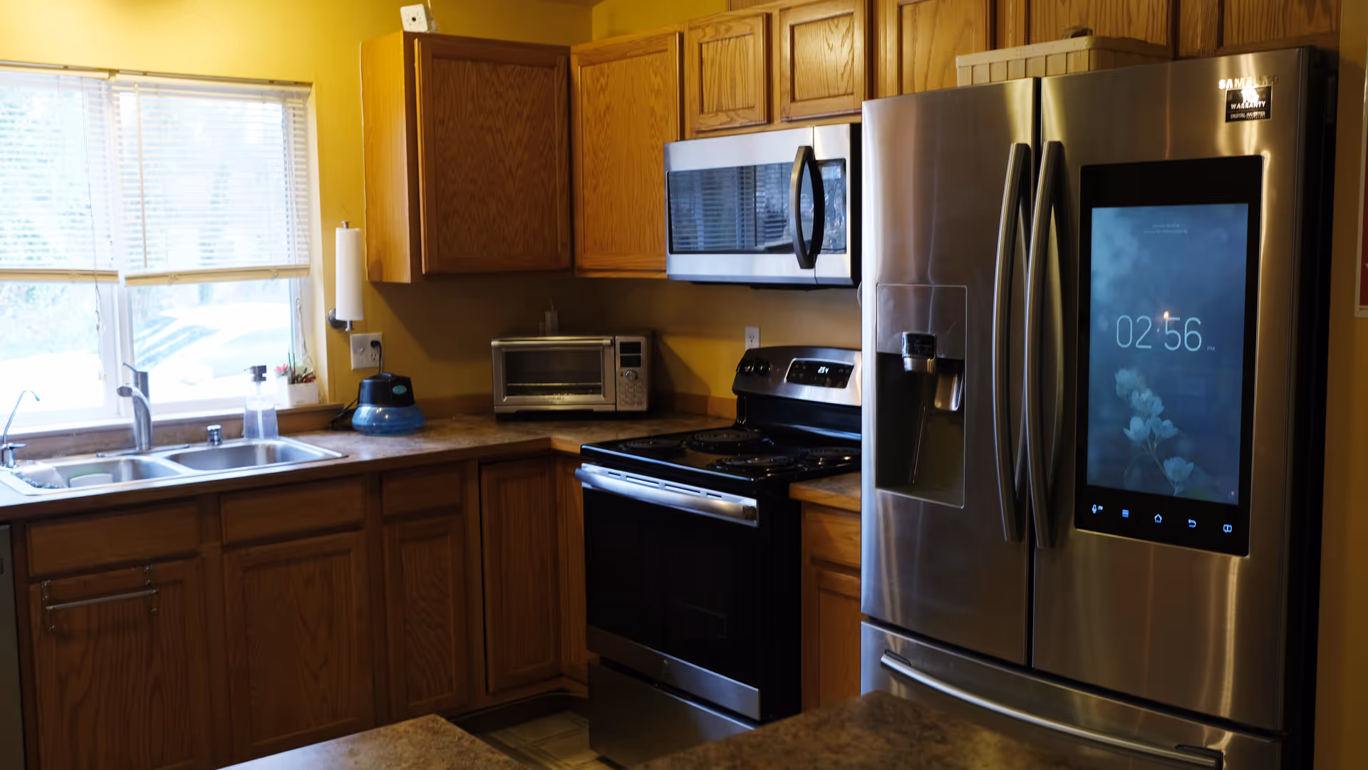 Homey kitchen with wooden cabinets, stainless appliances, and a large side-by-side refrigerator.