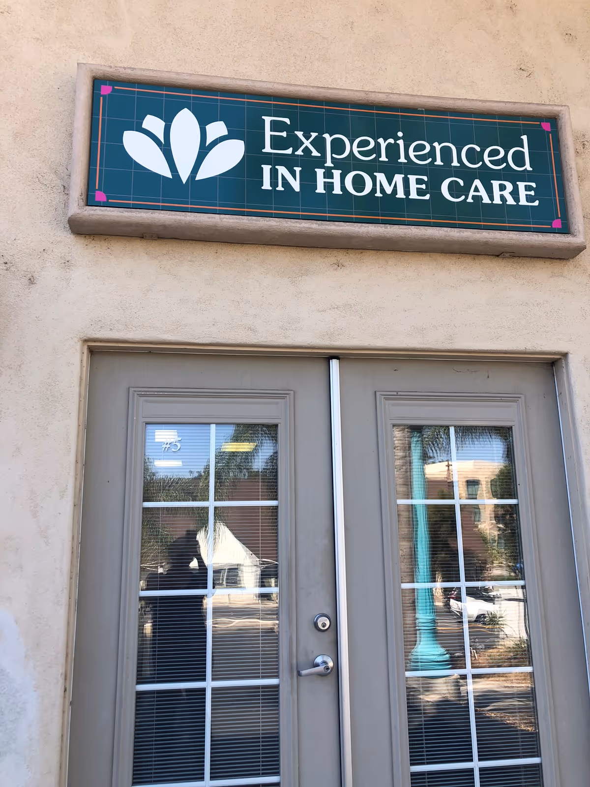 Exterior view of a facility entrance with a sign reading Experienced In Home Care.