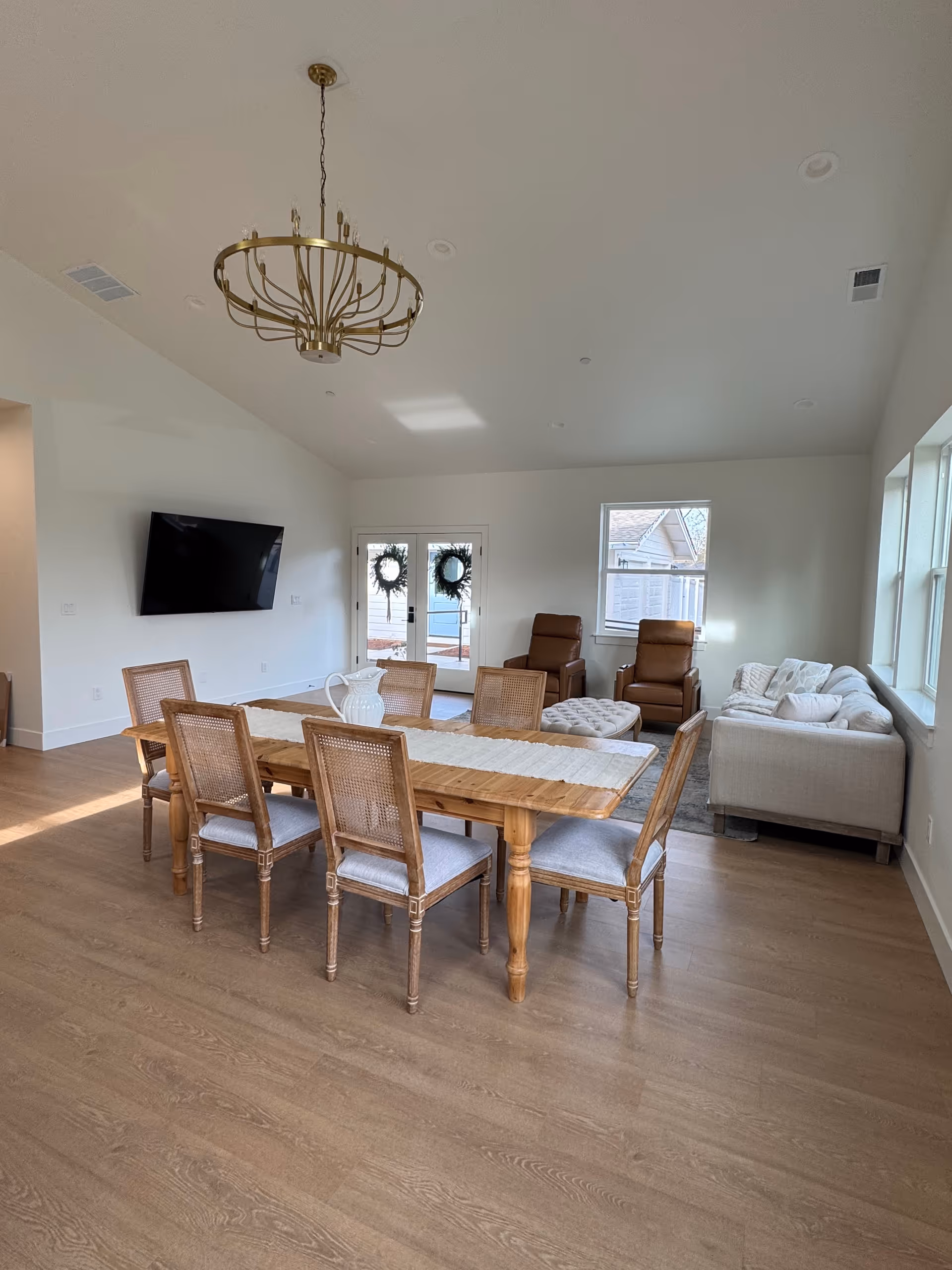 Bright open dining area with a long table, chairs, and seating.