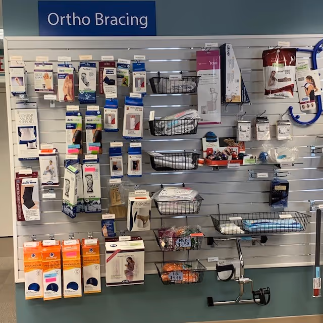Ortho bracing and medical supplies arranged on slatwall shelves.