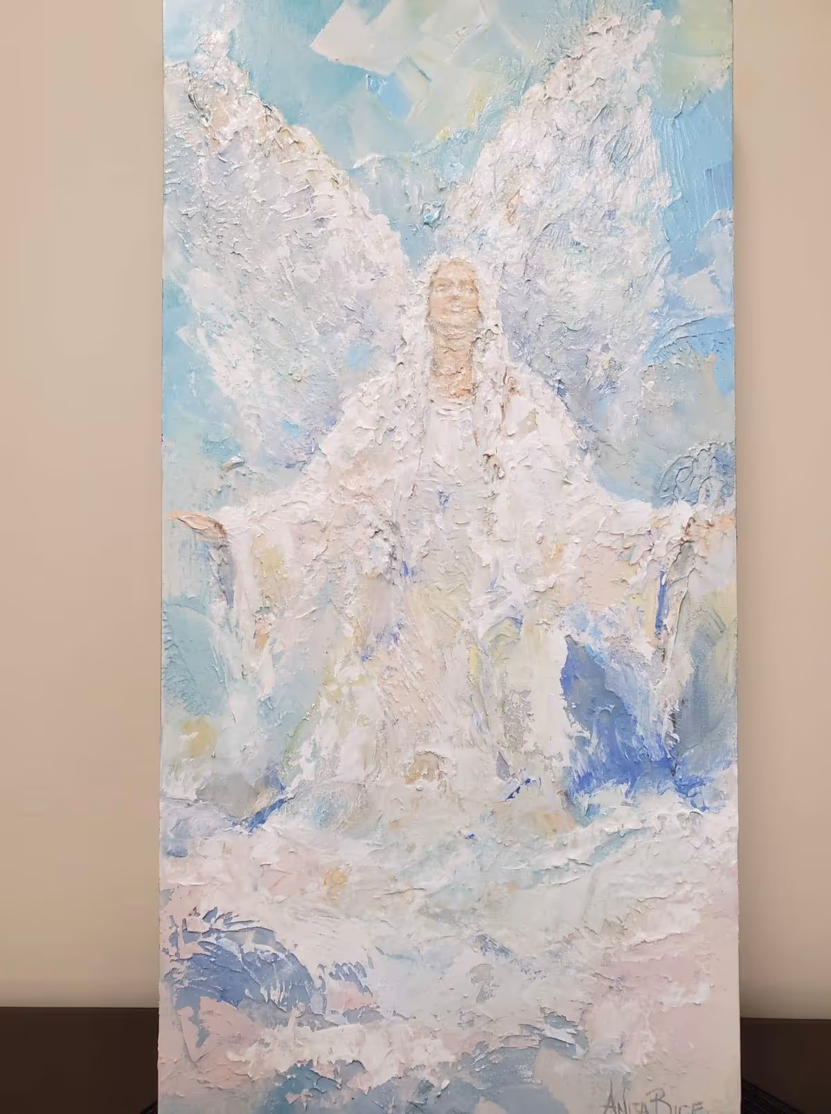 Abstract pastel painting of an angel on a wall inside a facility corridor.