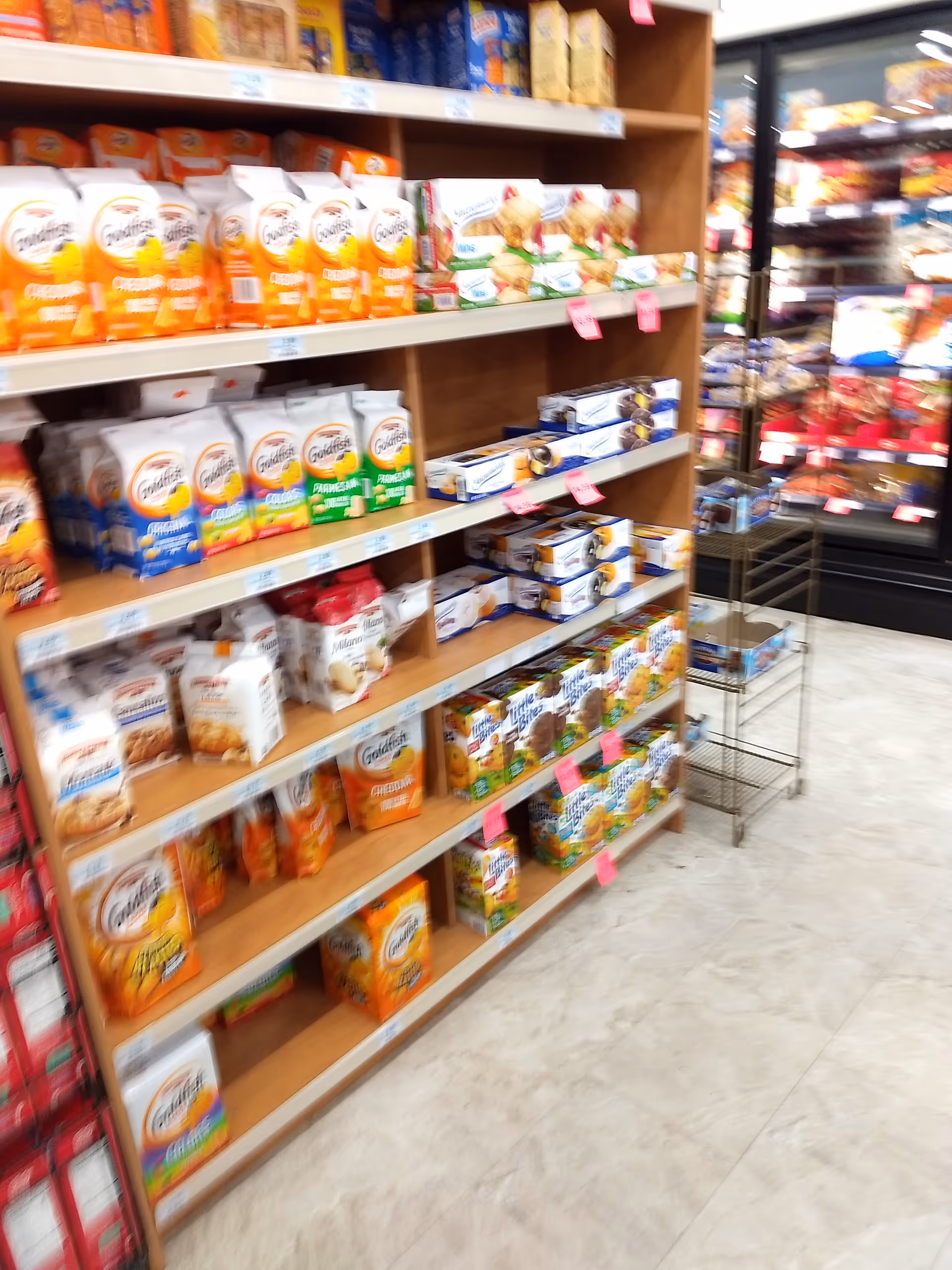 Blurred interior of a Discount Drug Mart aisle with shelves full of products.