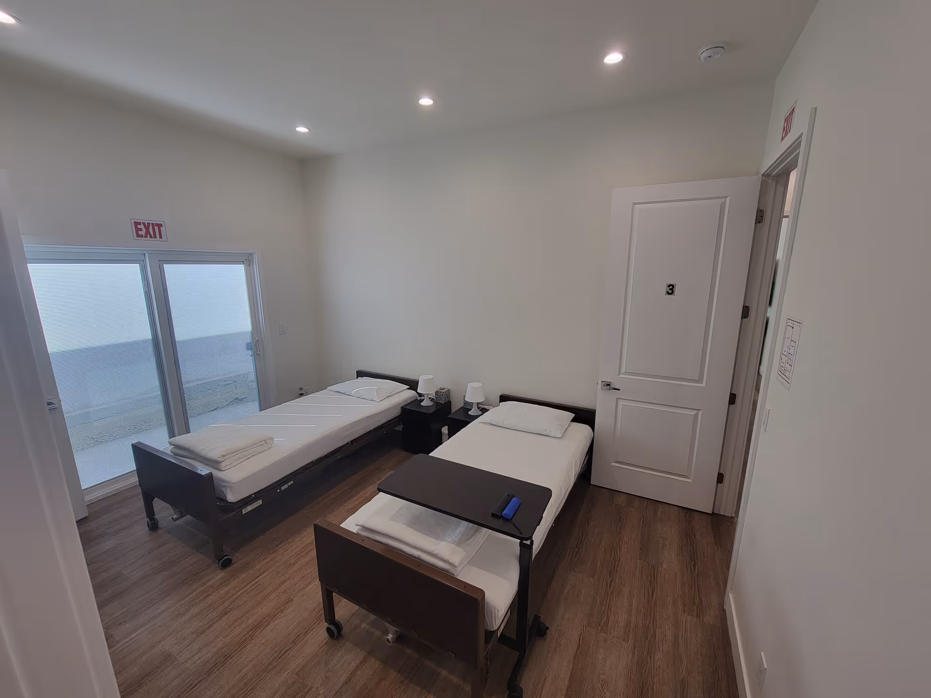 Two single beds with nightstands in a bright shared bedroom.