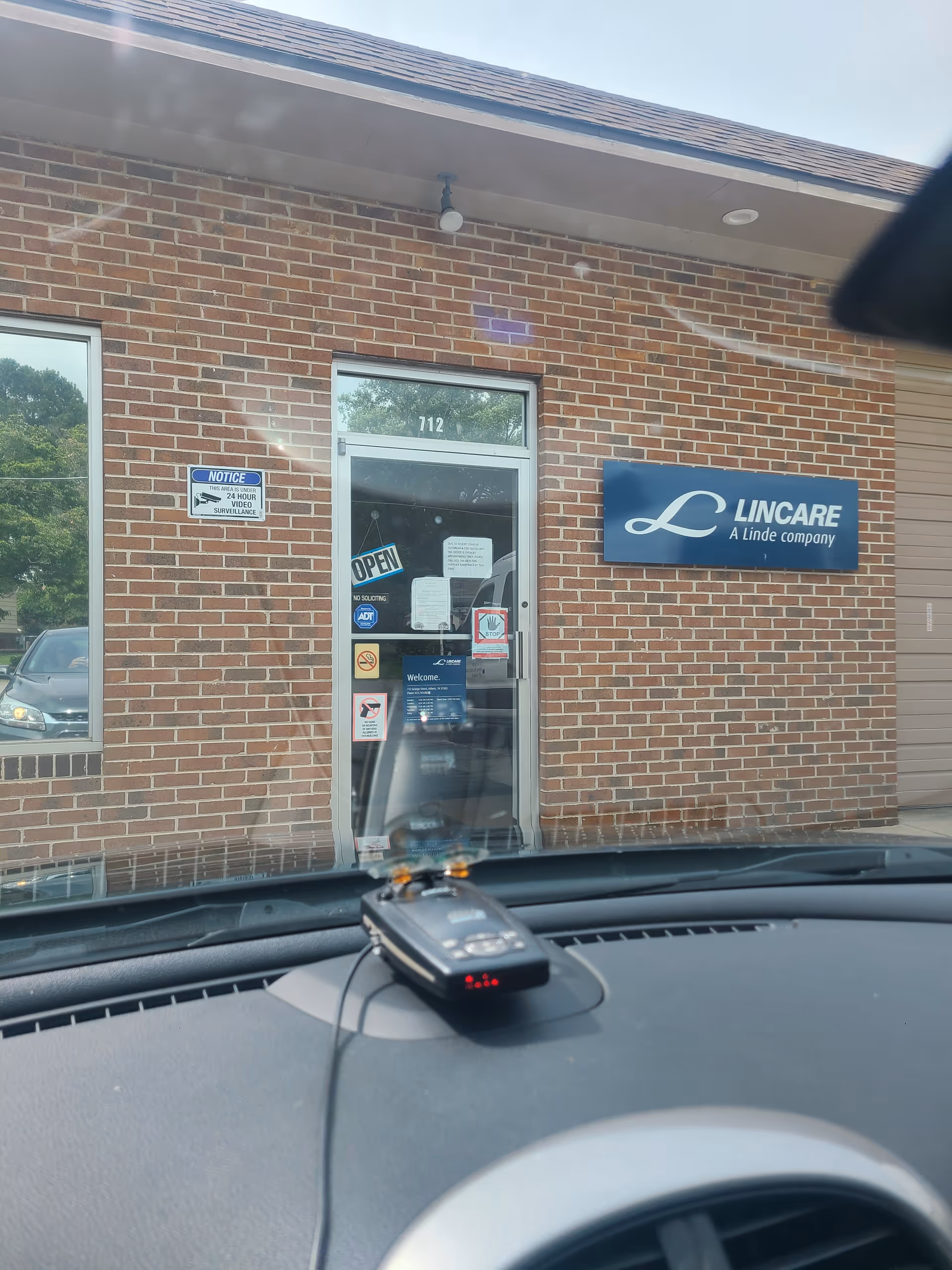 Exterior view of a LINCARE facility entrance on a brick building.