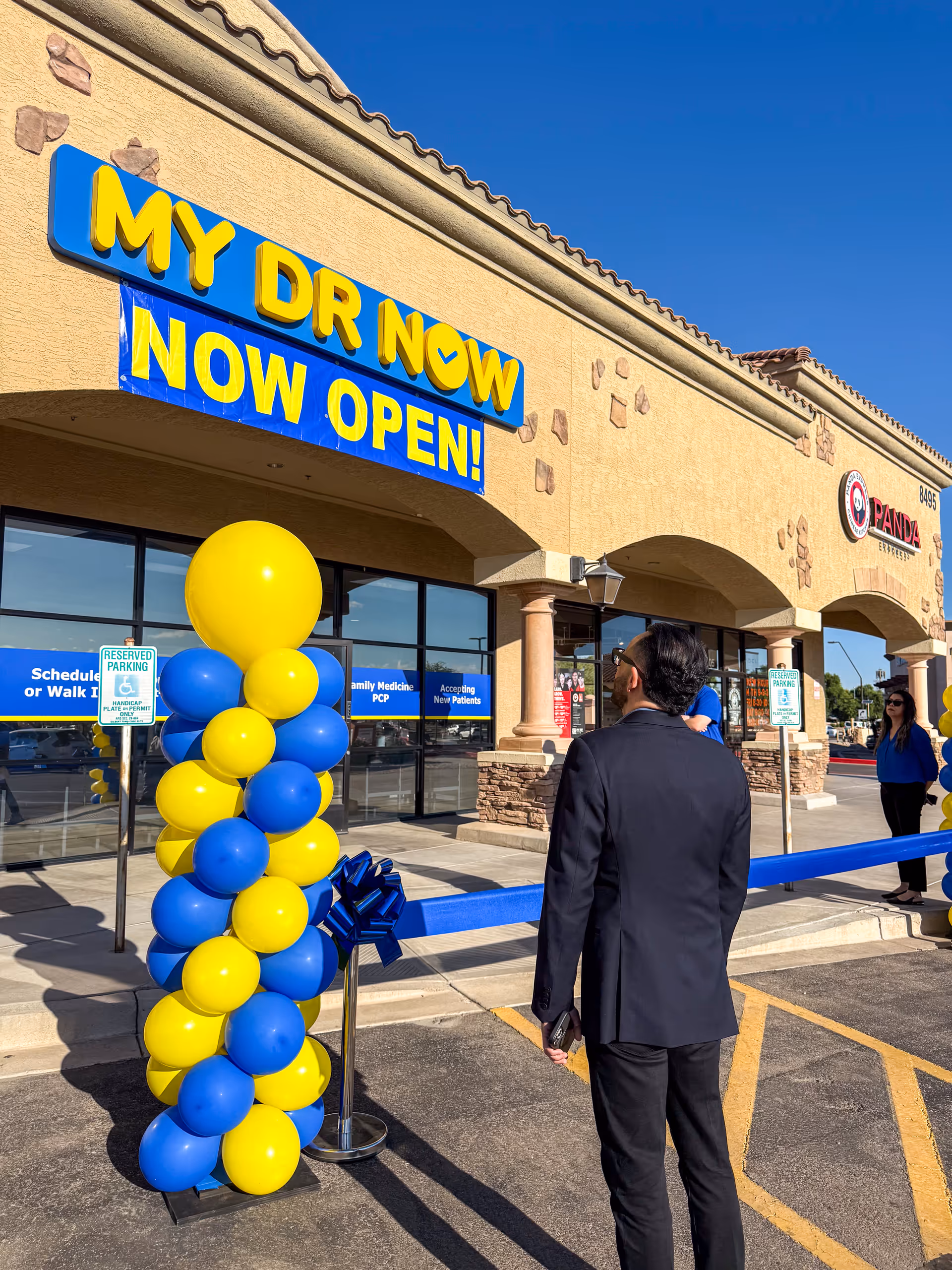 Front exterior of MY DR NOW with a NOW OPEN banner and balloons.