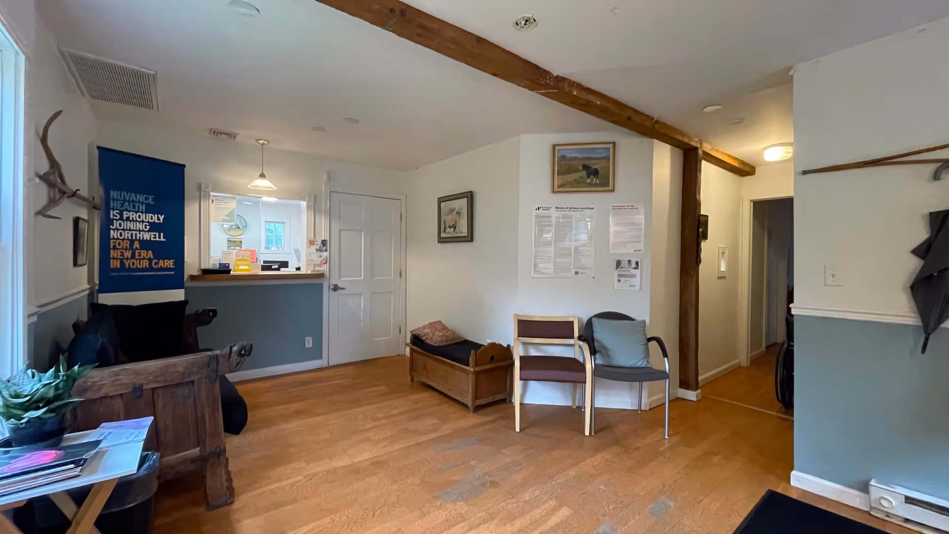 Reception area in a medical practice with a counter and seating.