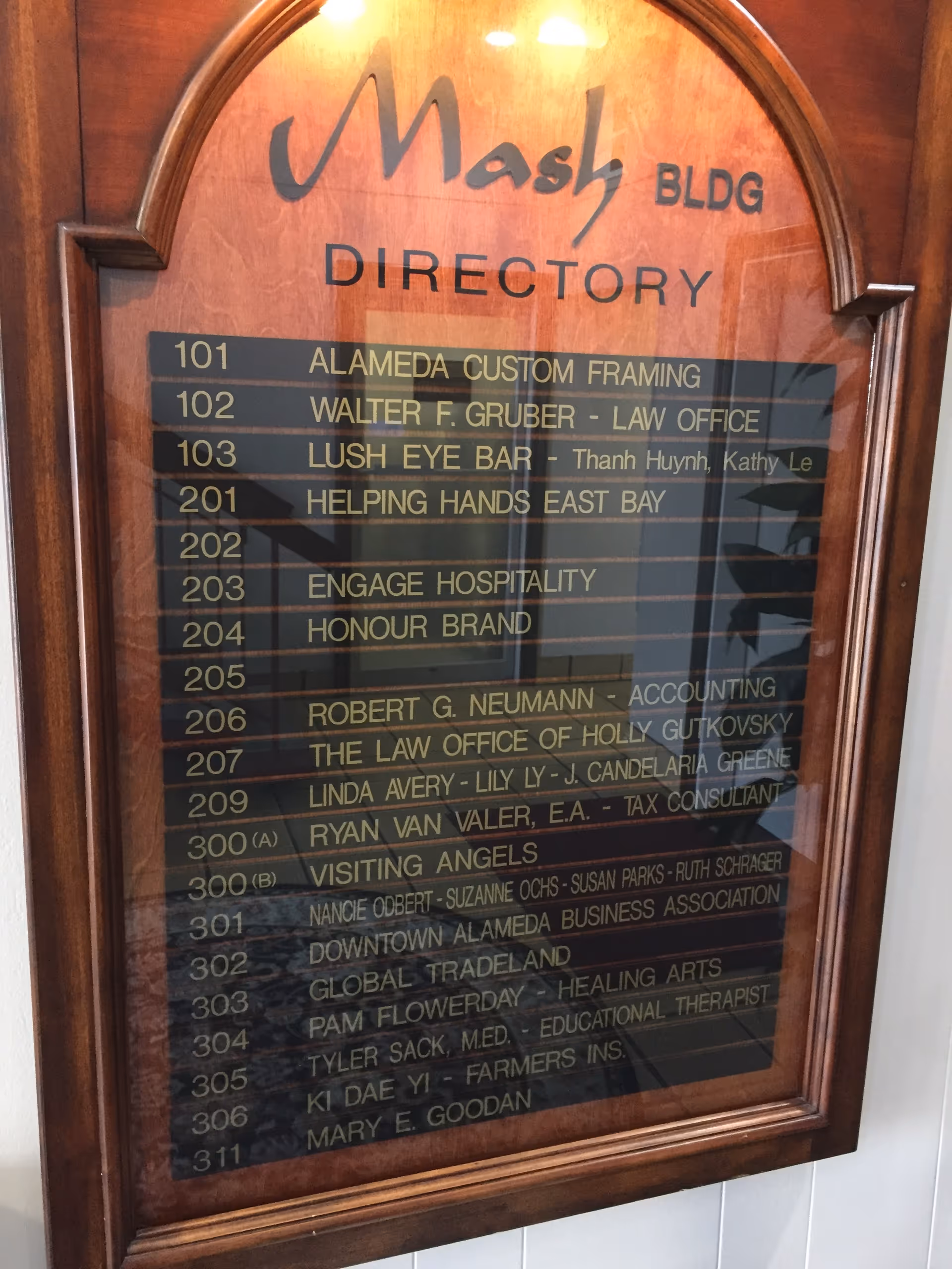 Wooden interior directory sign listing offices and room numbers.