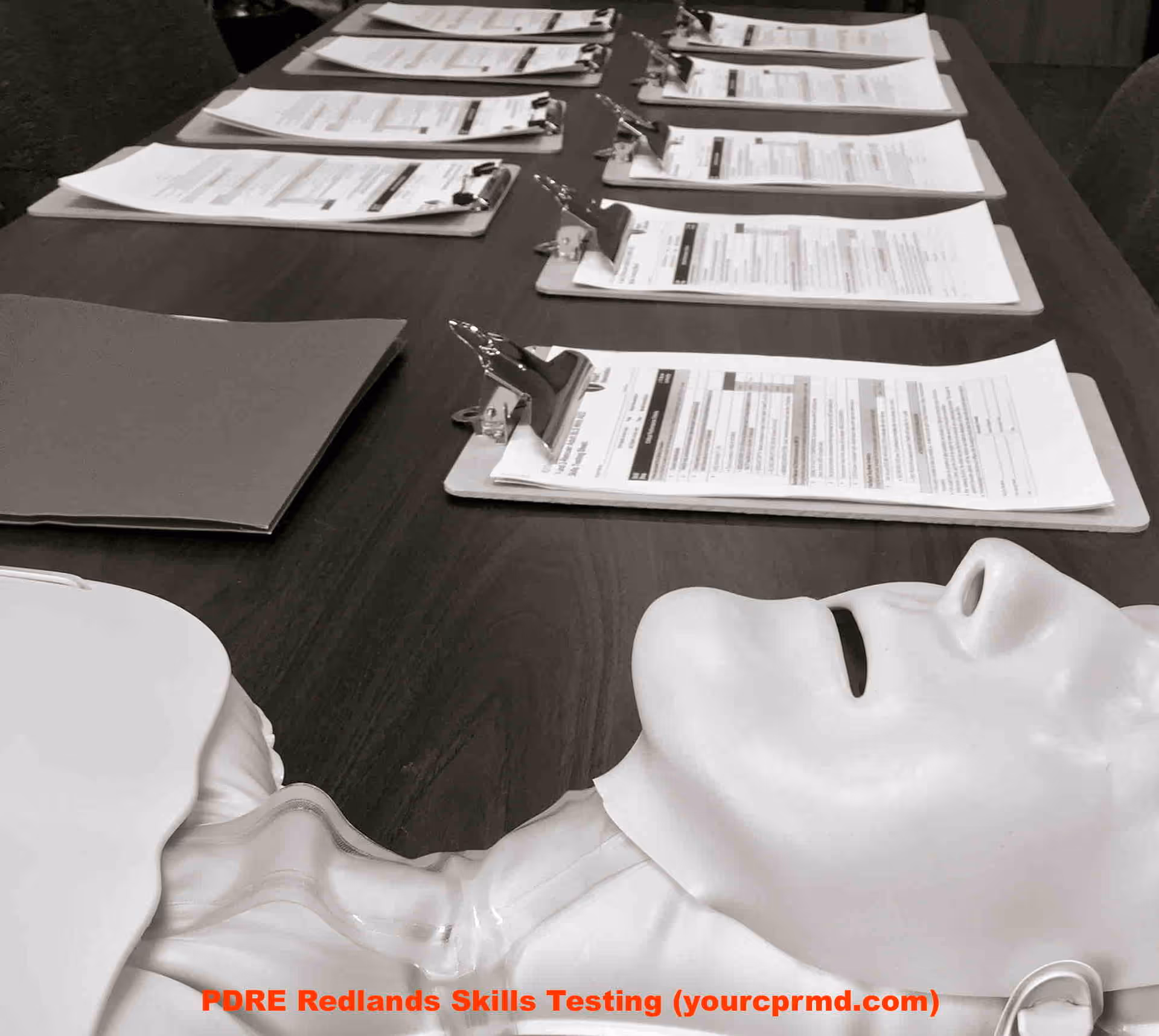 Training table with clipboards and a CPR mannequin head.