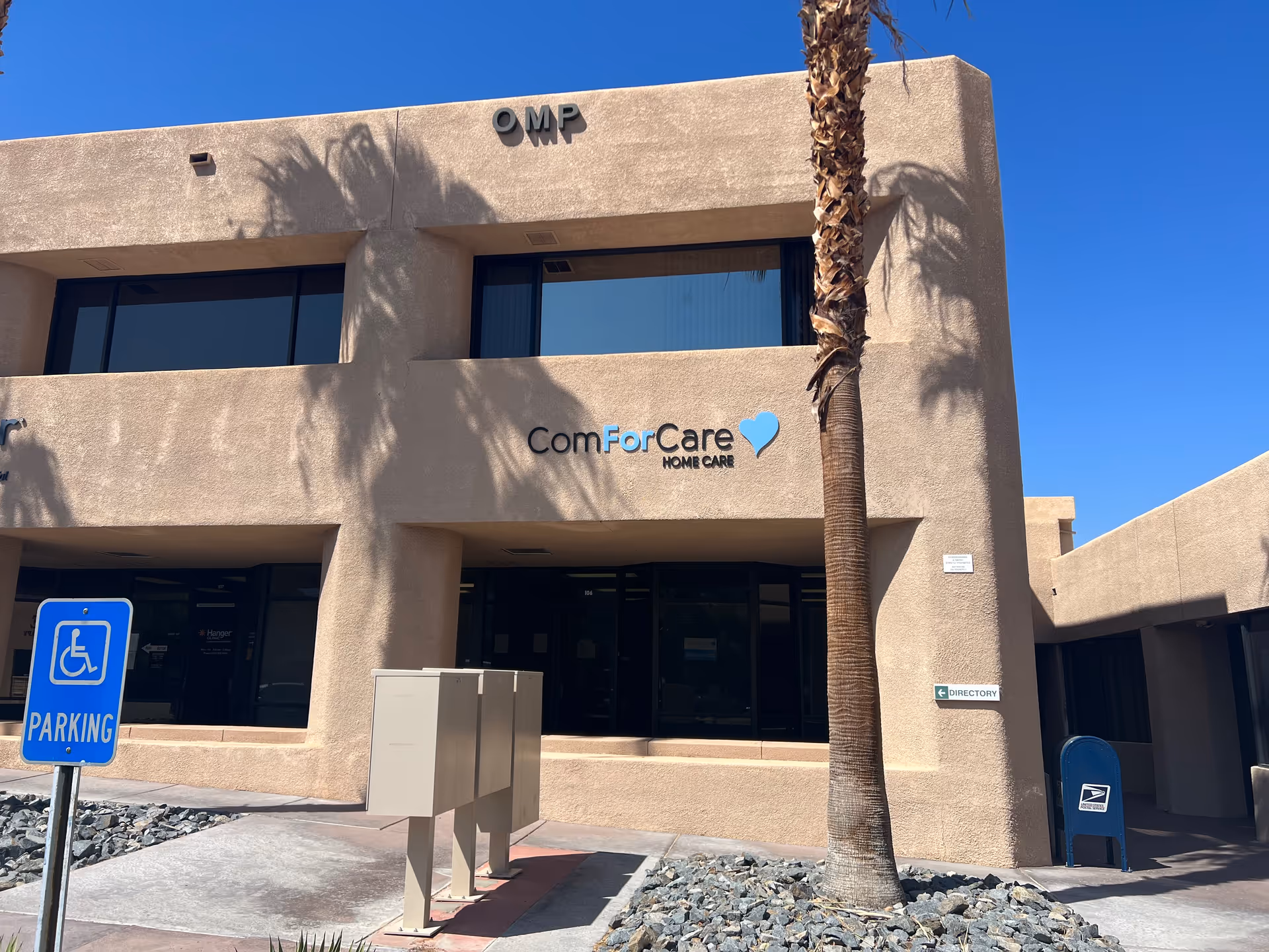 Exterior view of ComForCare Home Care building with palm tree and handicap sign.