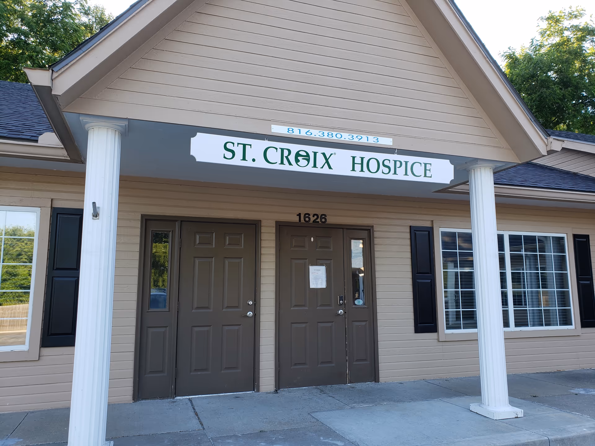 Front view of St. Croix Hospice building entrance with double doors and white columns.