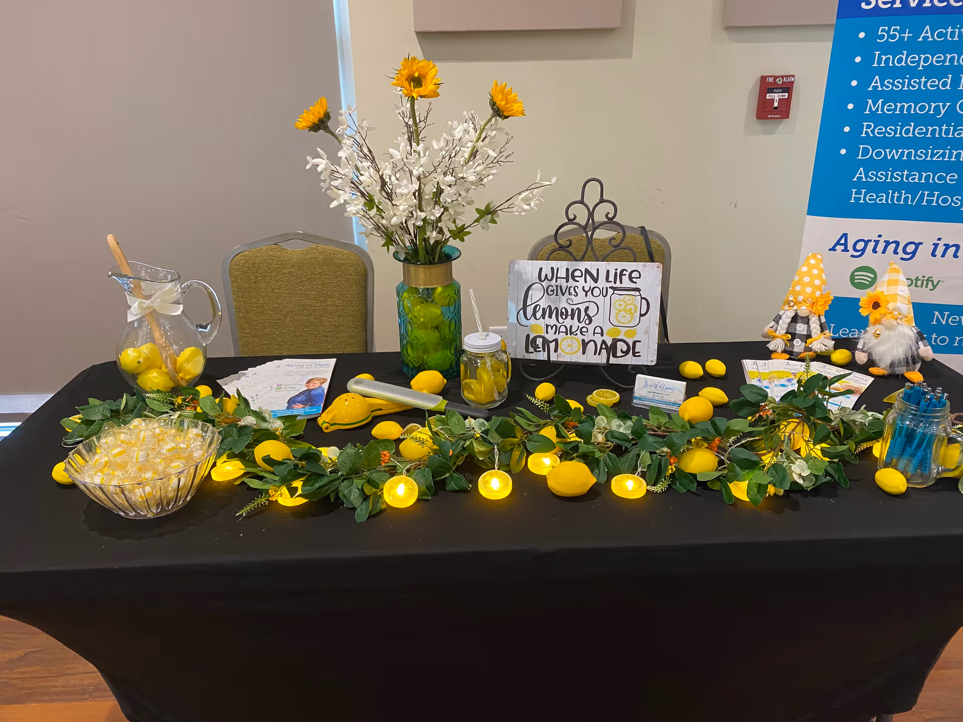 Lemon-themed decorative table setup with flowers and signage indoors.