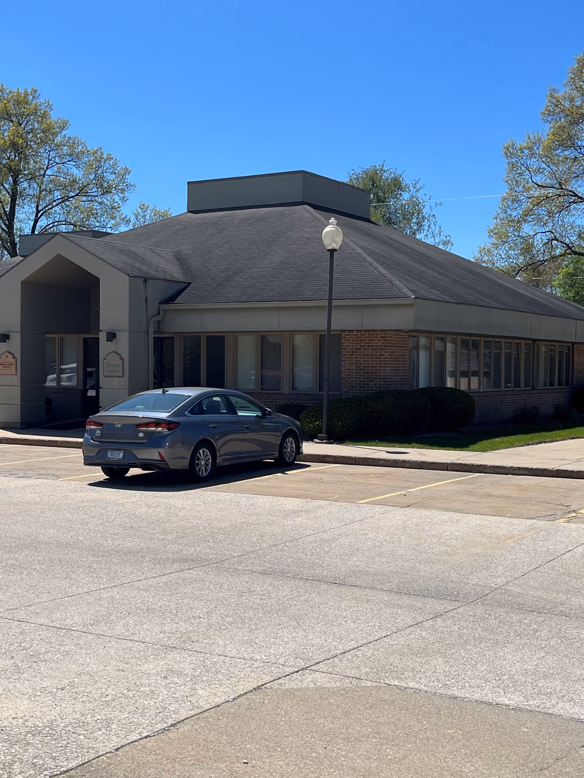Exterior view of Absolute Caregivers facility with a parked car in front.