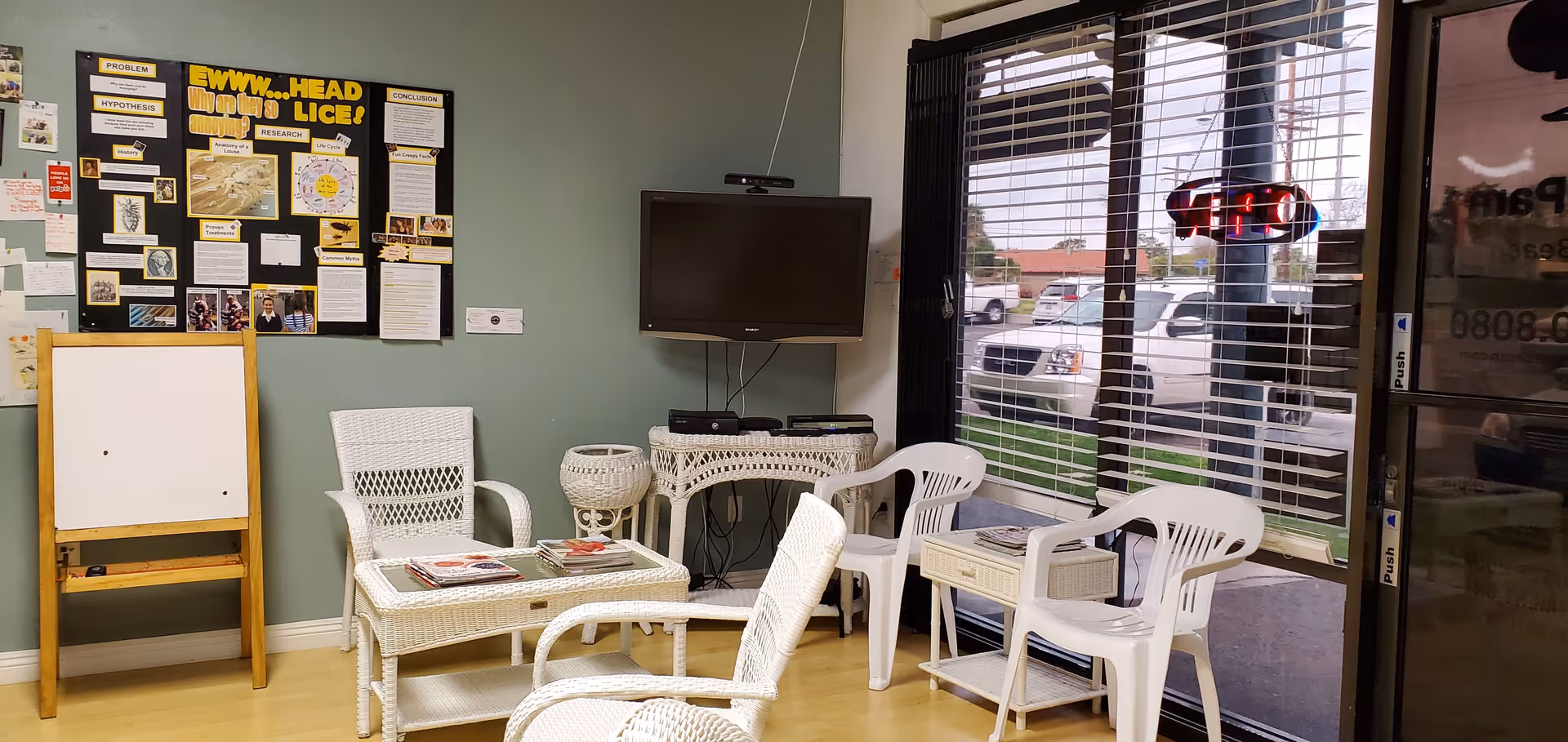 Interior lounge with wicker and plastic chairs, a TV, and bulletin board.