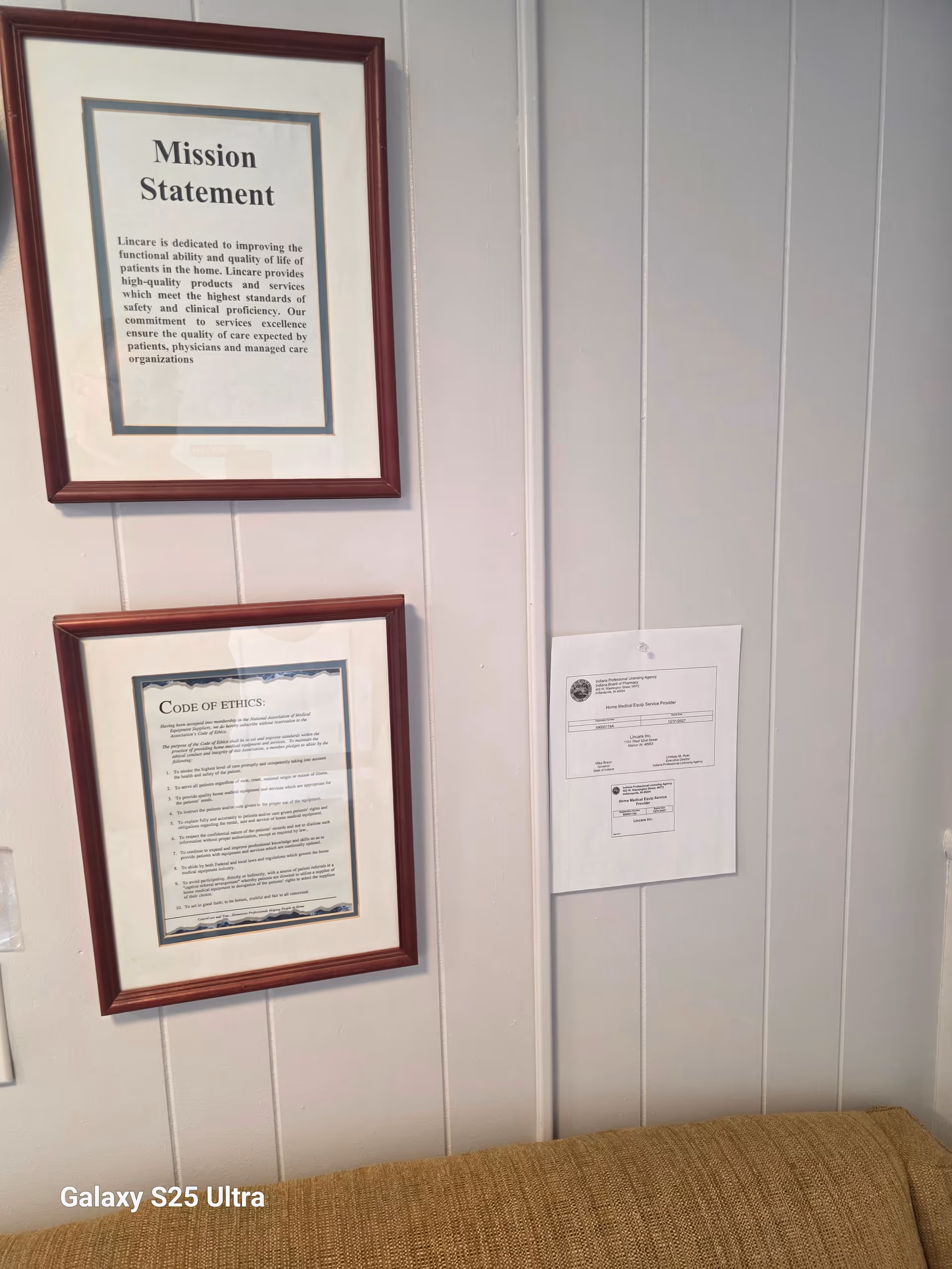Two framed documents labeled Mission Statement and Code of Ethics on a paneled wall.