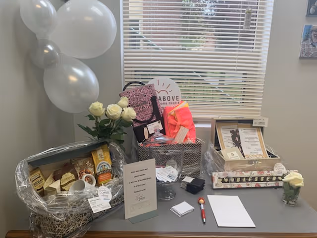 Reception desk at ABOVE Home Health with gift baskets, balloons, and flowers.