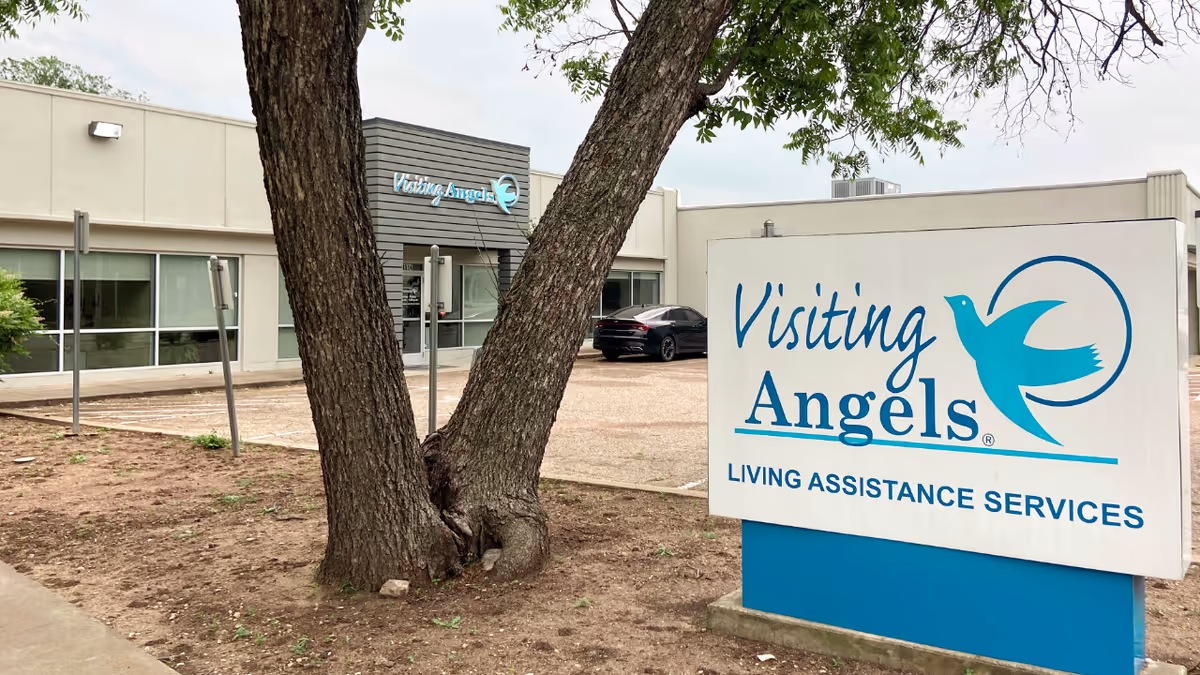 Exterior view of Visiting Angels facility with entrance and large sign.