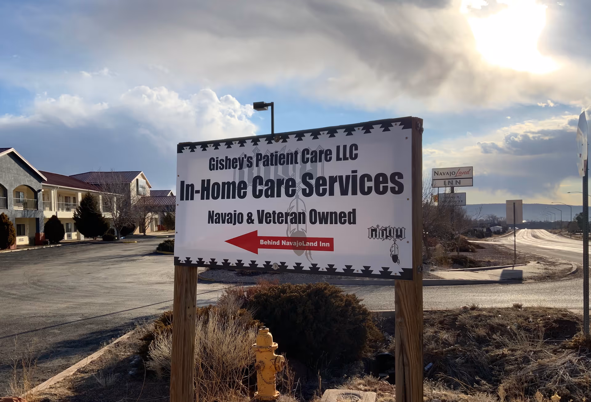 Outdoor sign advertising In-Home Care Services for Gishey's Patient Care LLC beside a parking lot.