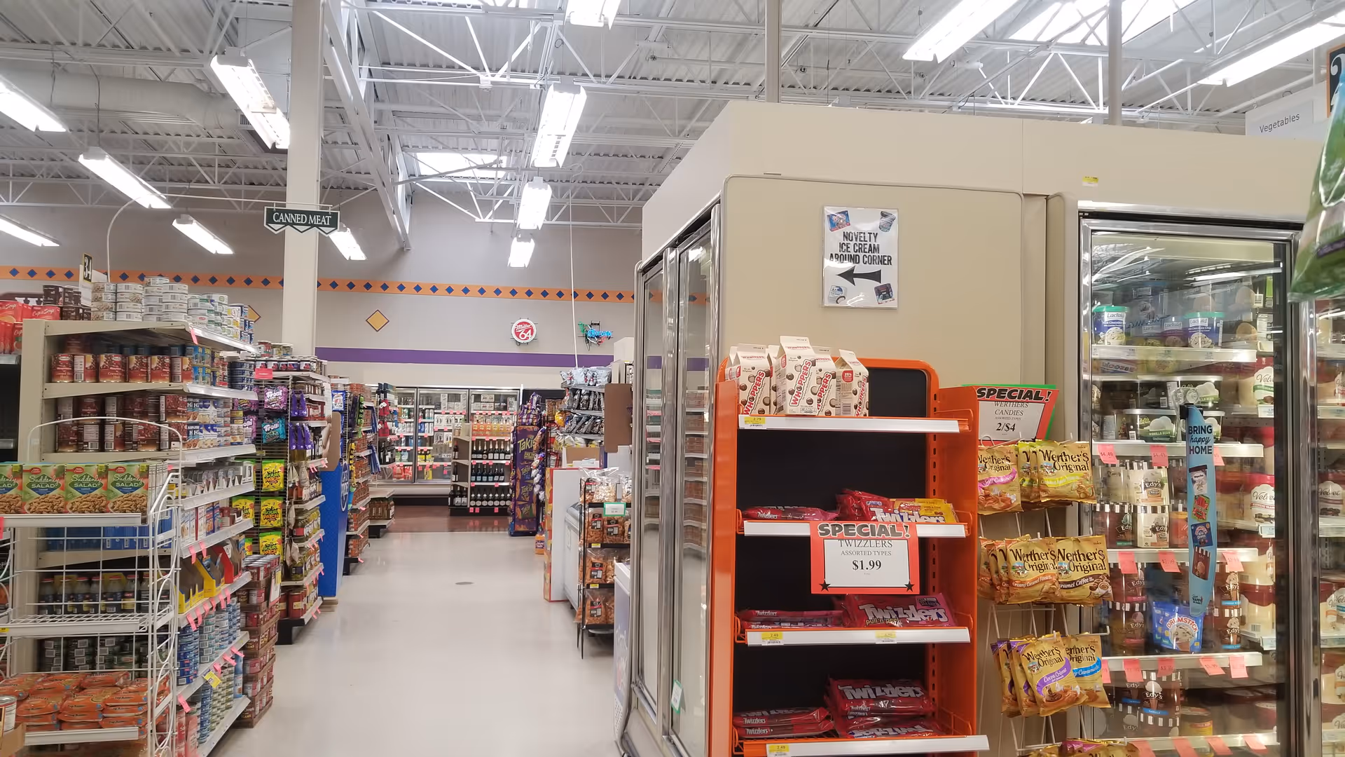Inside a Discount Drug Mart store, aisles stocked with groceries, snacks, and beverages.